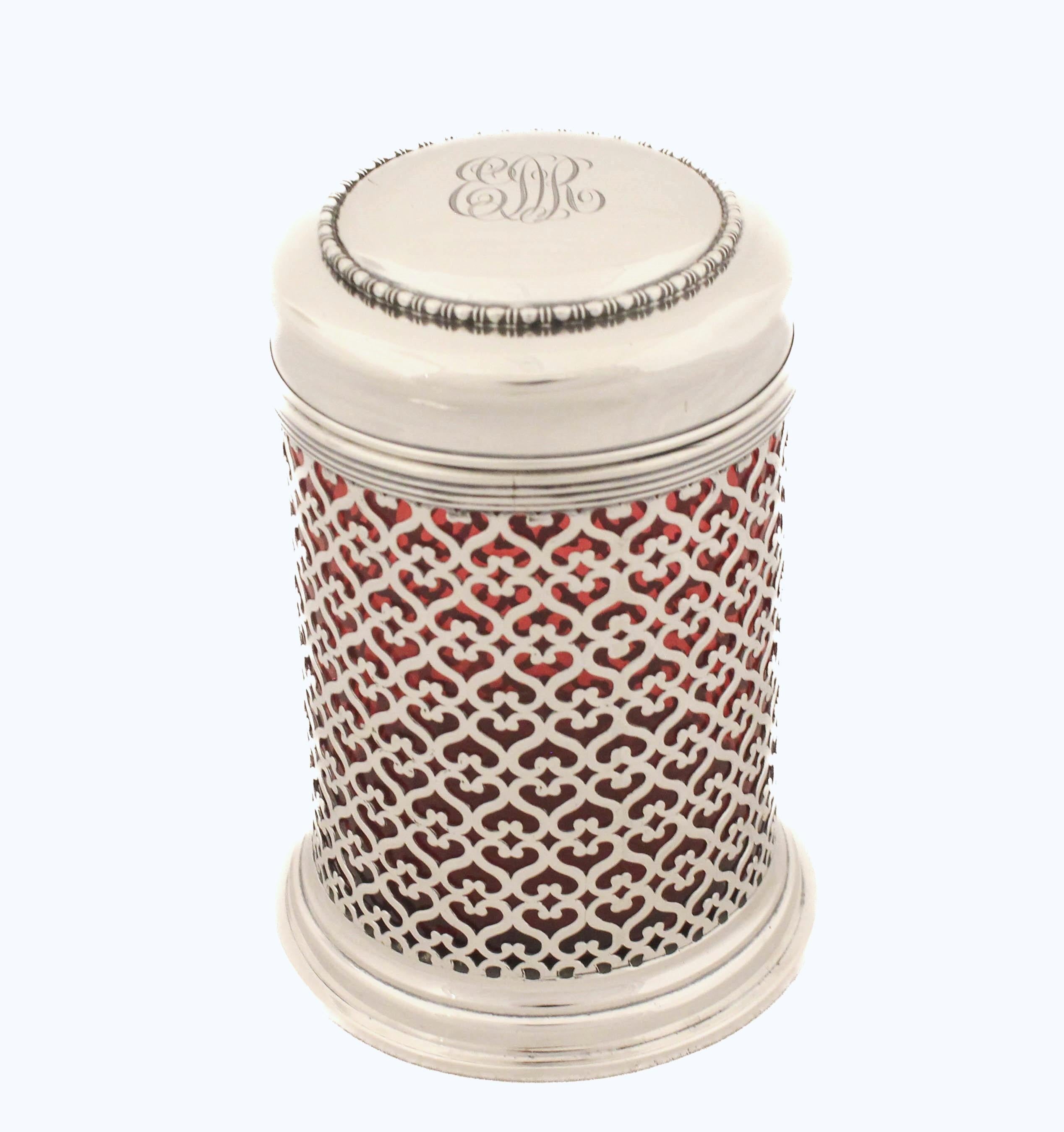 Viene offerto un grande vaso in argento sterling e un coperchio con un rivestimento in vetro color mirtillo rosso. L'intero corpo ha un design a reticolo, quindi il vetro rosso è molto evidente.  Il coperchio si chiude ermeticamente, per cui non
