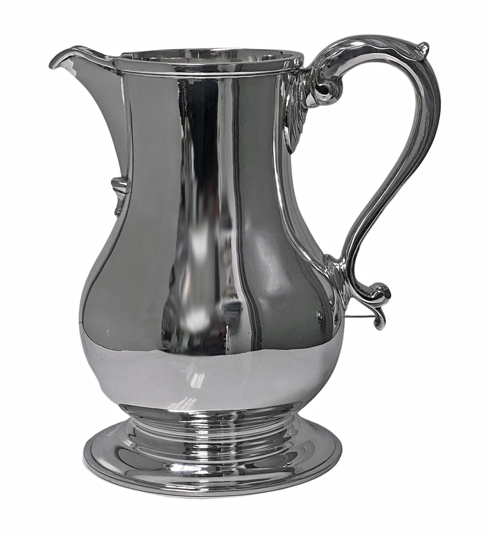 Georgian style sterling silver water/wine/beer Jug, London 1971 Wakely and Wheeler 36.25 oz. Large heavy impressive, plain baluster form on circular spreading foot, S scroll handle with acanthus thumb piece, plain moulded rim, and spout. Measures:
