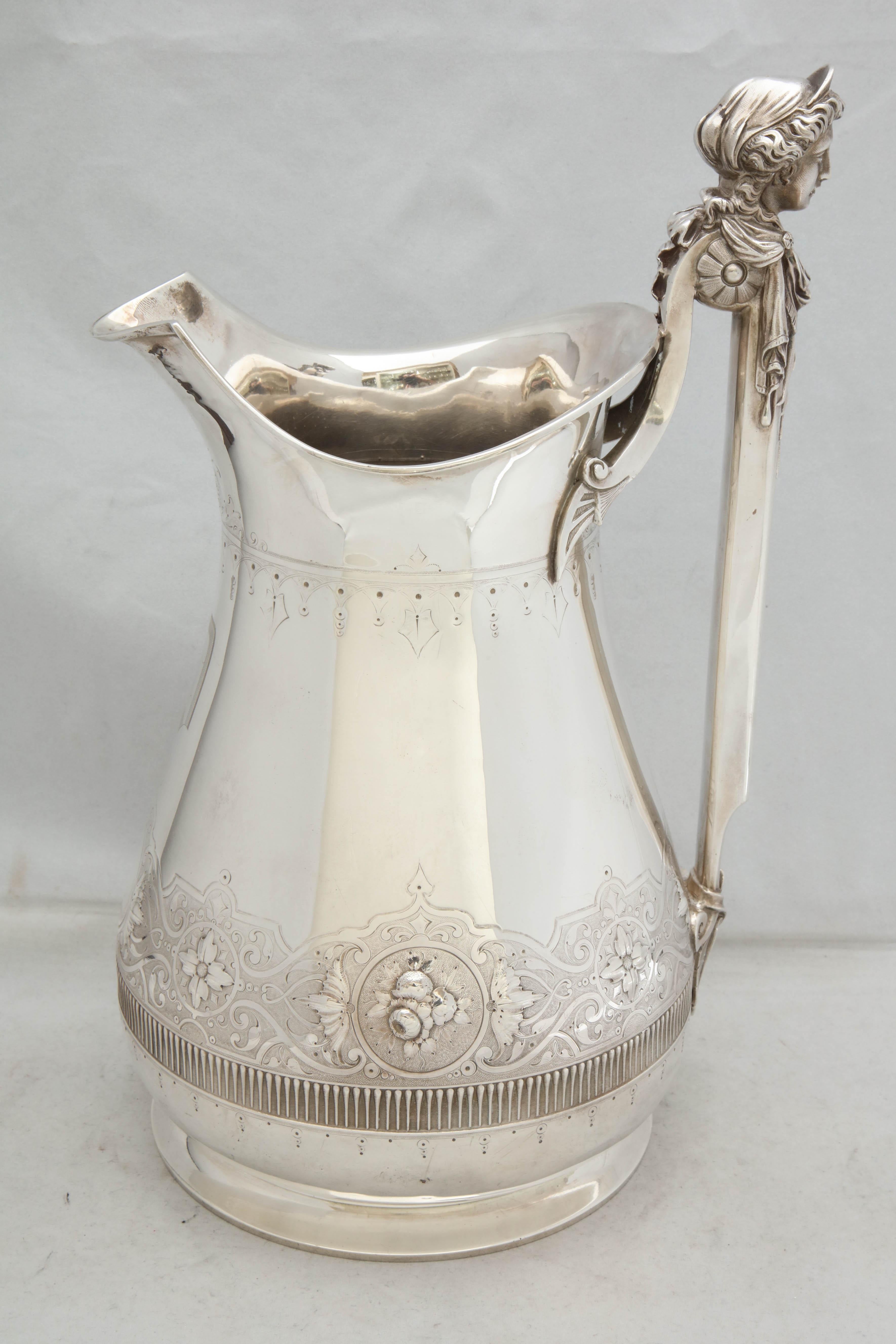 Large, sterling silver, Neoclassical pitcher, Gorham Manufacturing Company, Providence, Rhode Island, circa 1870. Chased with flowers; handle is topped with a classically draped woman's head. Monogrammed with an Old English D. Measures 12 1/2 inches