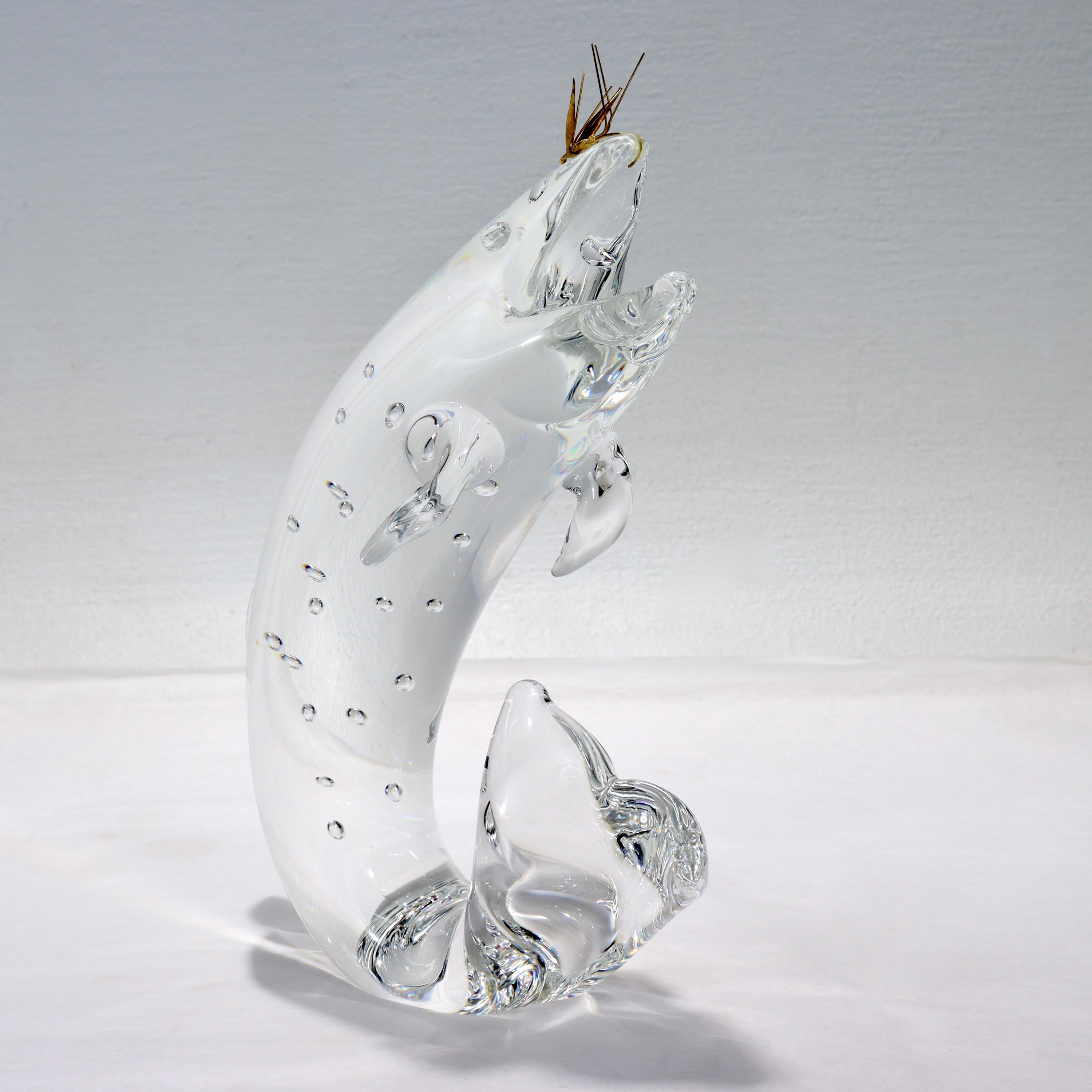 A fine Steuben art glass model of a trout just caught by an 18 karat gold fly.

Designed by James Houston in 1966. 

Model No. 2011.

Simply a wonderful figural sculpture of the peak moment in fishing!

Date:
20th century

Overall