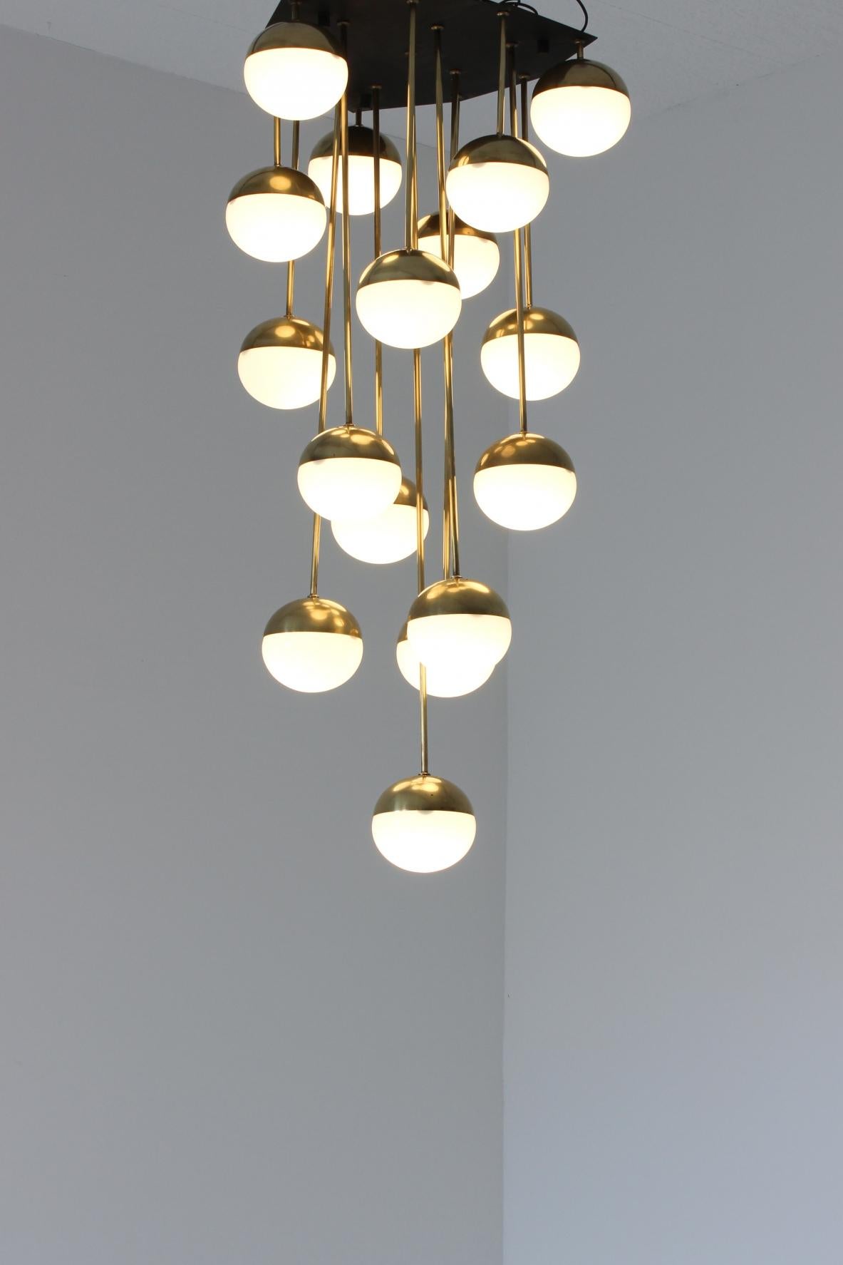 Large 18-light chandelier with brass structure and opaline glasses.

Shaped metal ceiling plate.

Stilnovo production, 1960s.