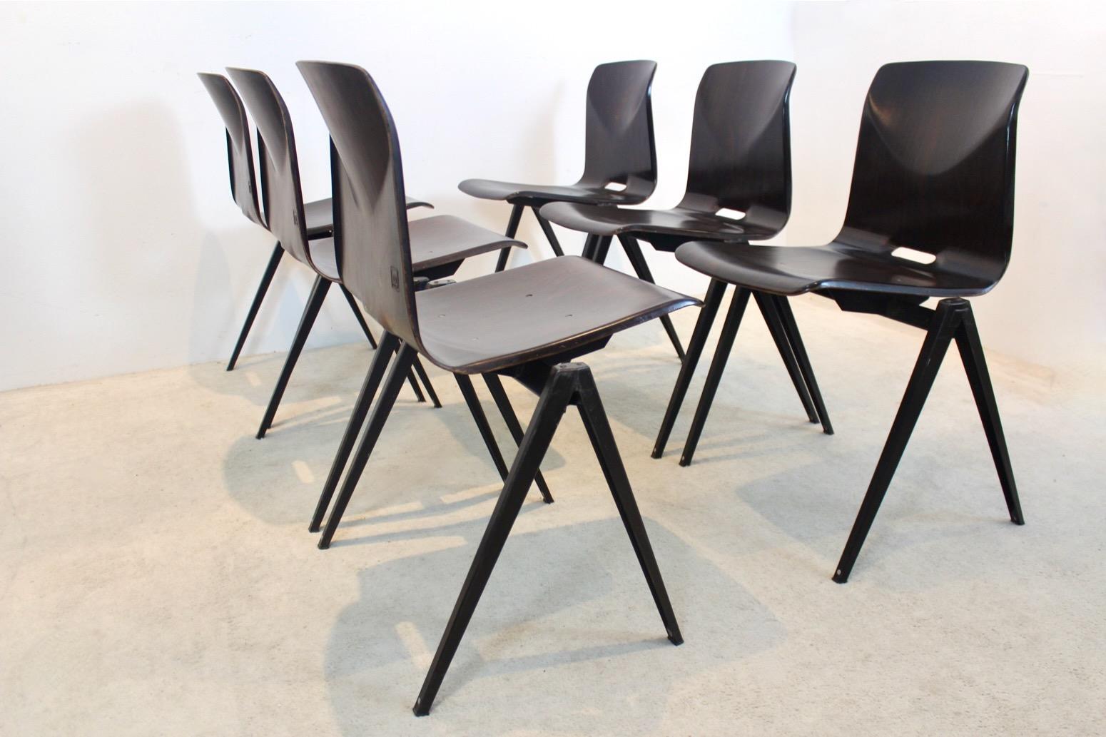 Highly wanted industrial model S22 stacking chairs by Pagholz.Galvanitas, in Wenge color with very dark brown frame. The shells have a beautiful flamed motive and wood grain structure.

Designed in the manner of famous industrial designs by Wim
