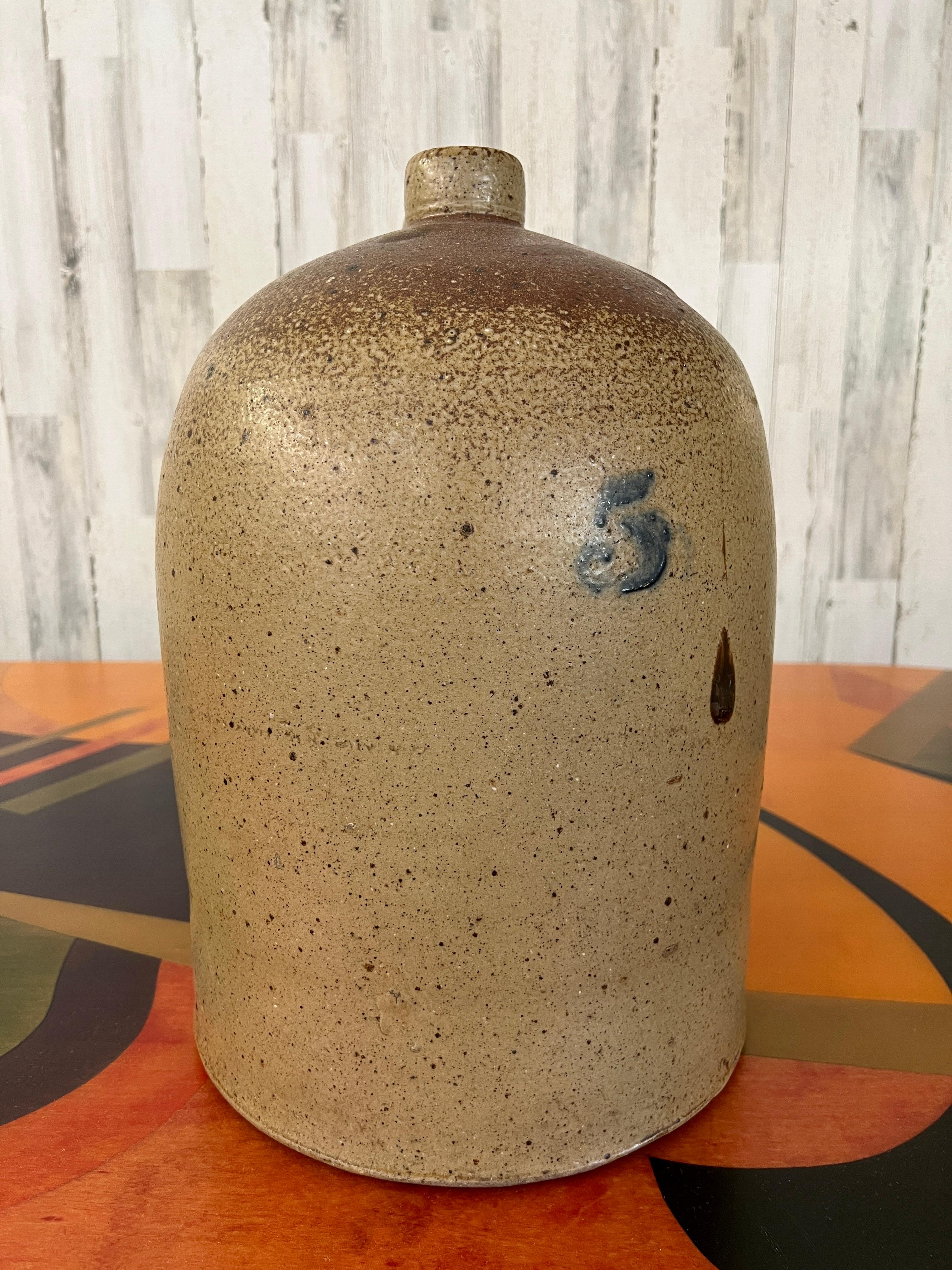 Large Stoneware jug with speckled glaze and cobalt number 5 also several drips of glaze.