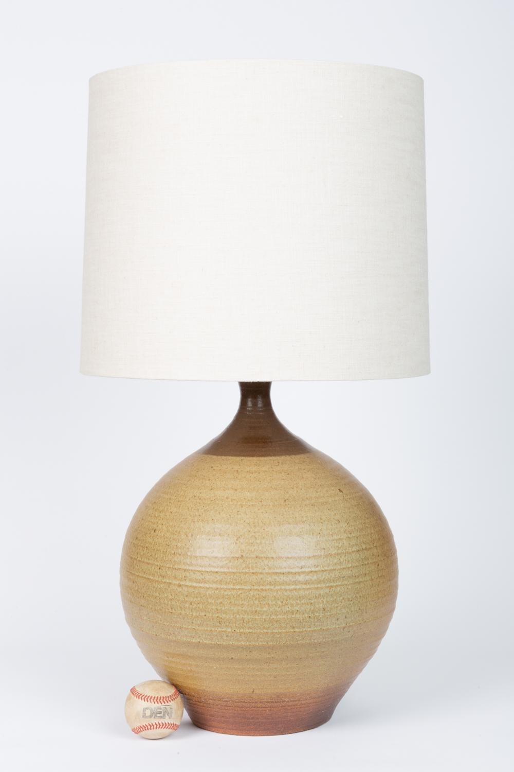 A large stoneware lamp by California ceramicist Bob Kinzie for his company, affiliated craftsmen. The wheel-thrown curved body of the ceramic lamp is lightly ribbed in texture and has a brown color-blocked band at the base and where the vessel