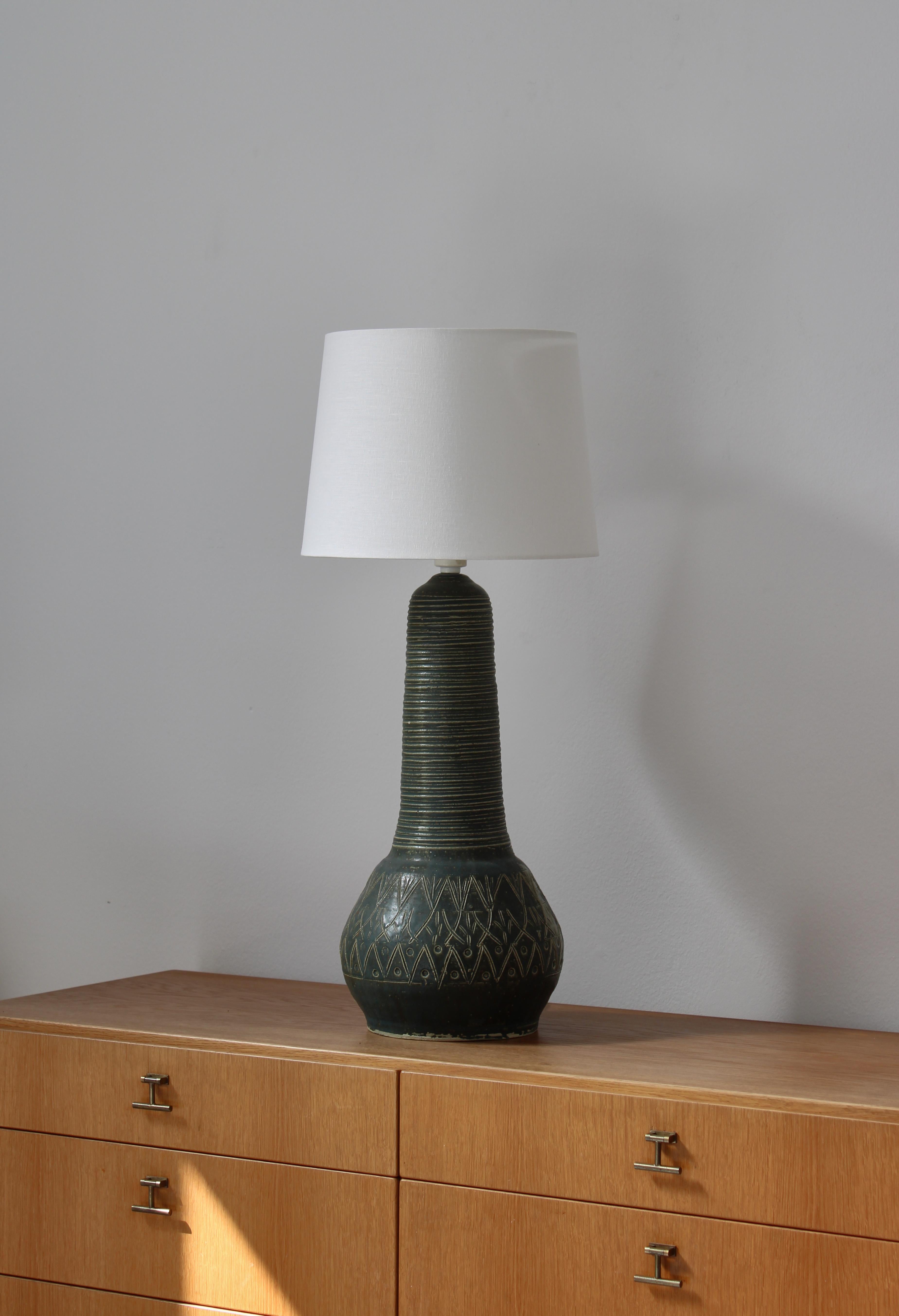 Large handmade table lamp made in the 1960s in Denmark in modern style. Beautiful green glazing and abstract organic incised decorations. Unsigned but of high quality in the style of 