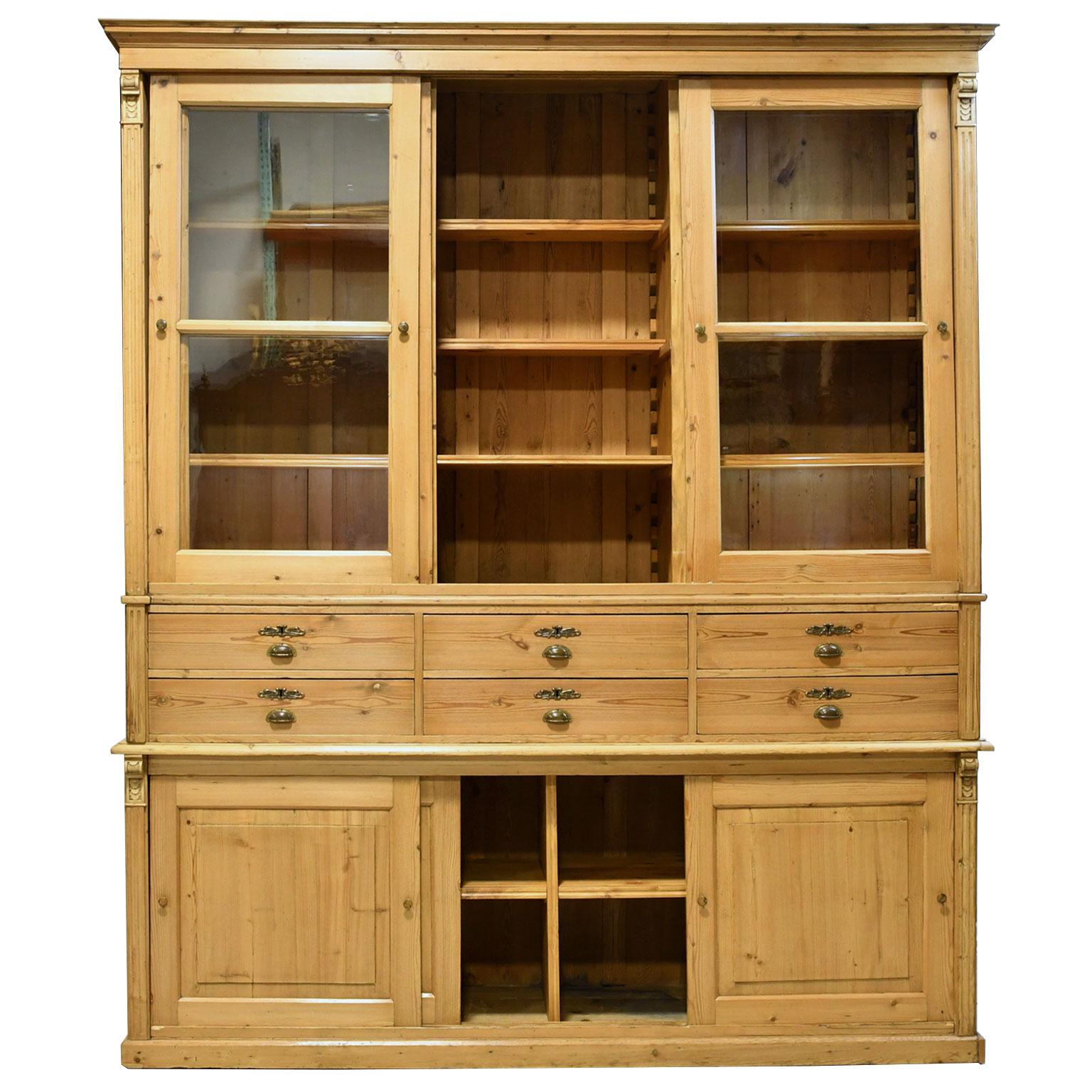 An exceptional cabinet in light-colored pine, that likely was made for a store or boutique, given its large size and configuration. It offers lots of storage comprising of three sliding-glass doors for display above two rows of drawers (that total