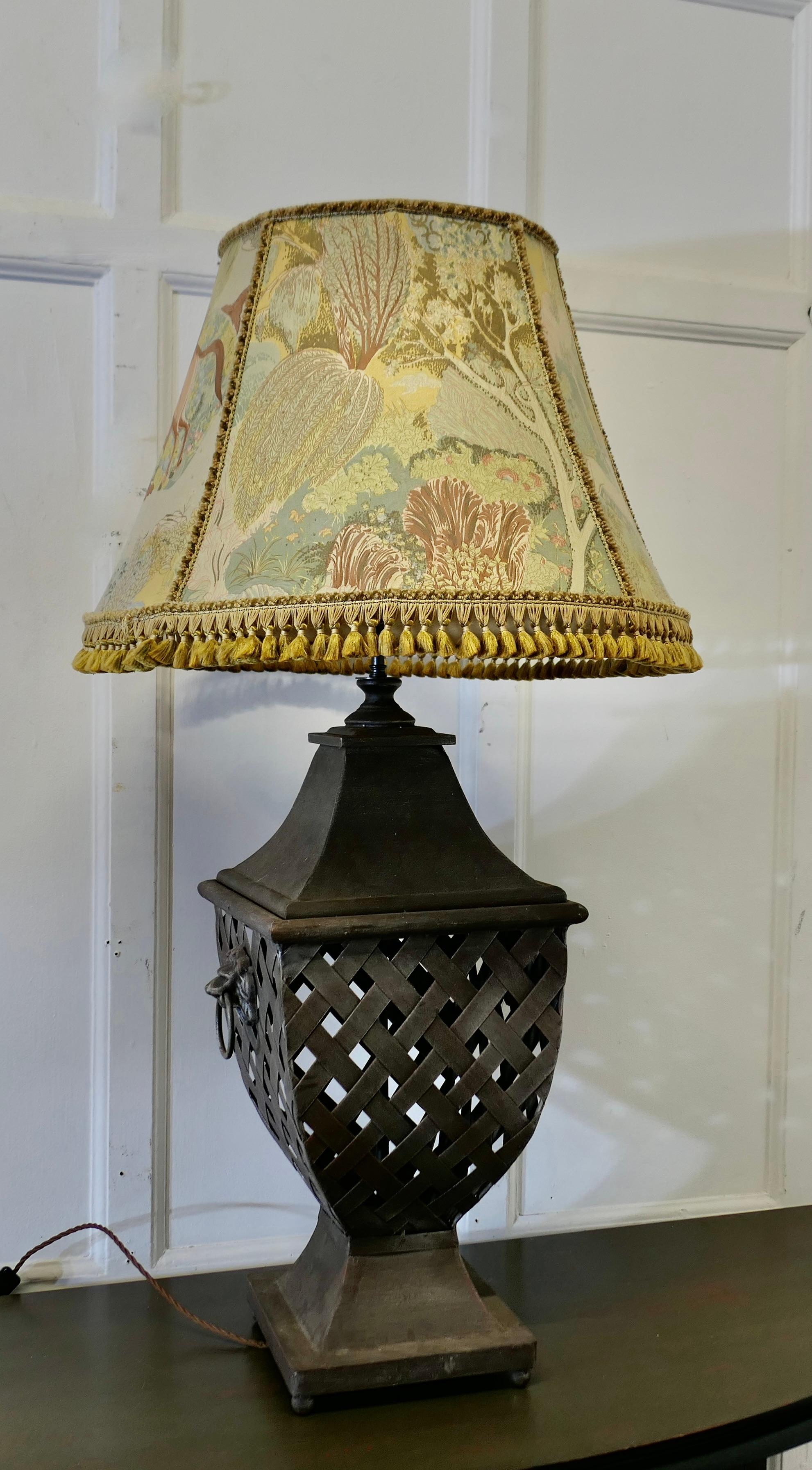 Large Strapwork Iron Lamp with Jungle Lamp Shade

This is a very attractive and large lamp the base is made with iron in a lattice weave with handles 
The lamp comes with a magnificent linen shade, this has jungle scenes with trees and animals
The