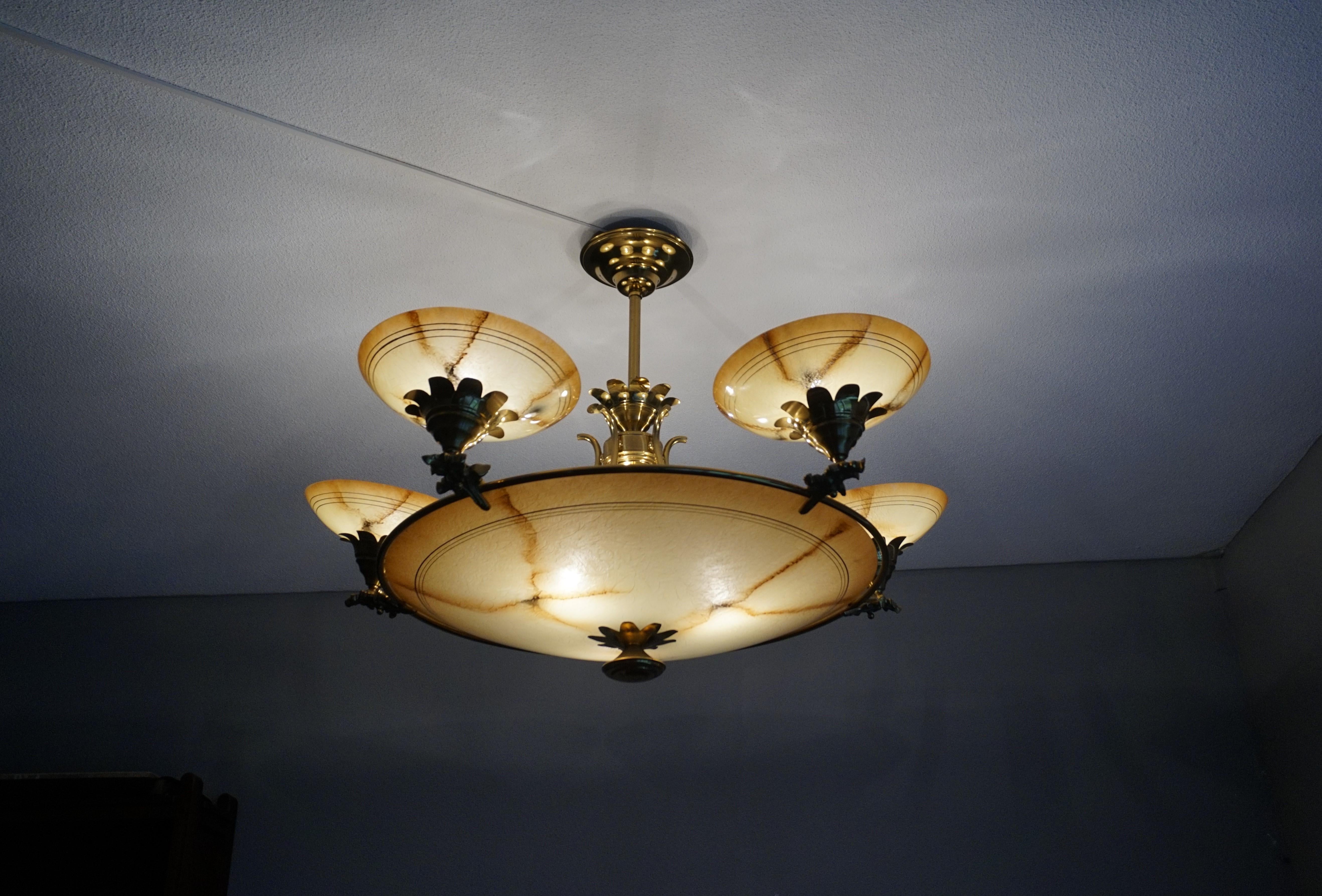 Stunning, Art Deco meets Hollywood Regency chandelier.

If you are looking for a good size chandelier with a unique and great looking design then this midcentury era fixture could be perfect for you. With as much as 8 bulbs (five in the glass shades
