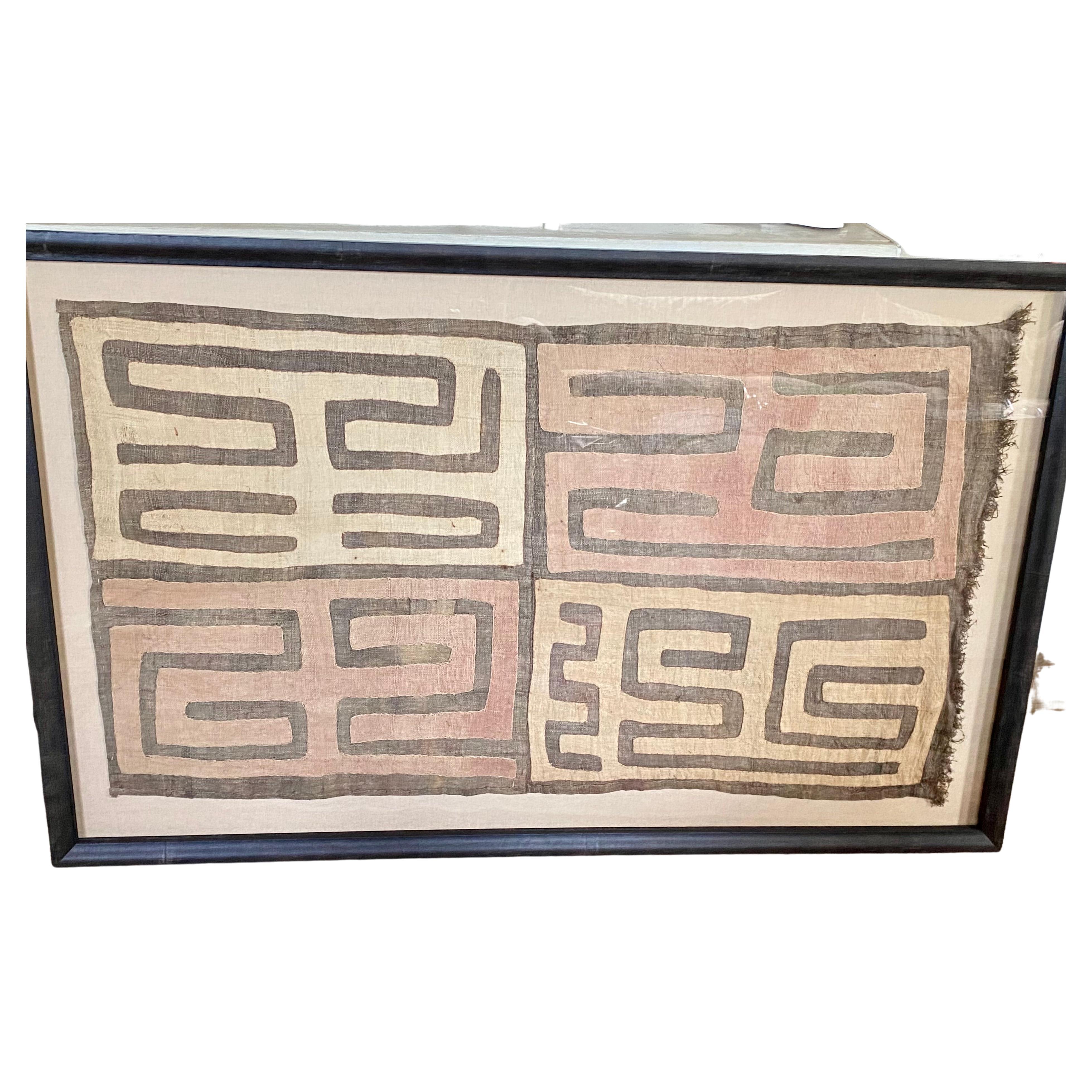 Large impressive graphic geometric African Kuba cloth in handsome custom frame having neutral color palette of beige and brown.