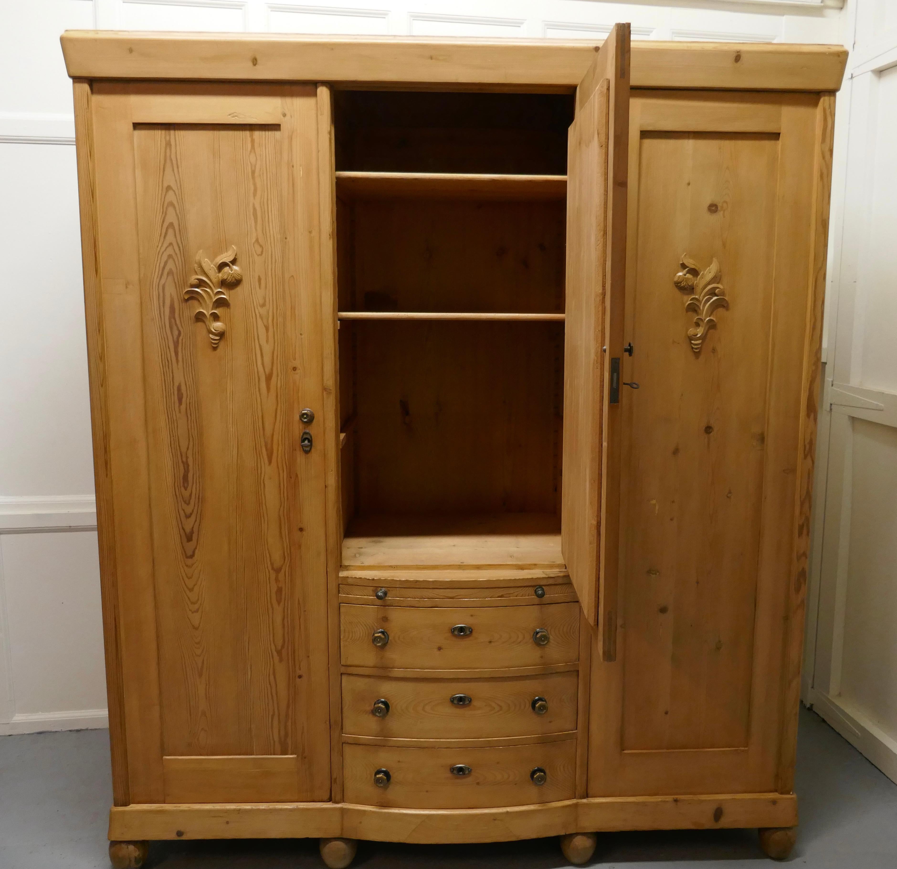 Large stripped pine wardrobe compactum,

The wardrobe has 3 doors, 2 enclosing a good size hanging space and the centre mirrored door encloses a shaved cupboard 
Below this cupboard there is a pull out slide and 3 bow fronted drawers 
The