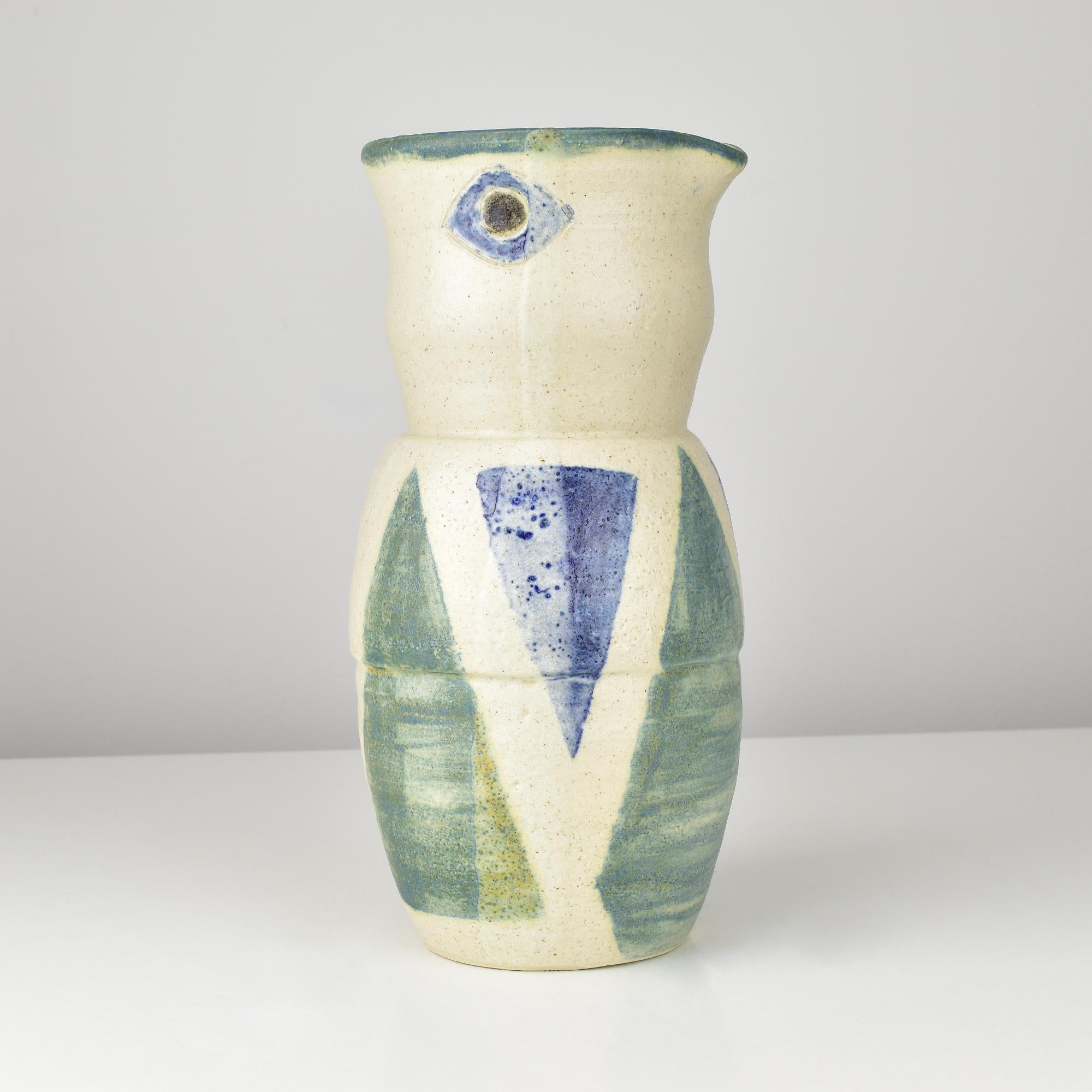 This striking large studio art pottery vase features an abstract geometric design reminiscent of Picasso's style. Crafted from stoneware, the vase showcases bold hand-painted triangular and diamond-shaped motifs in shades of blue and green against a