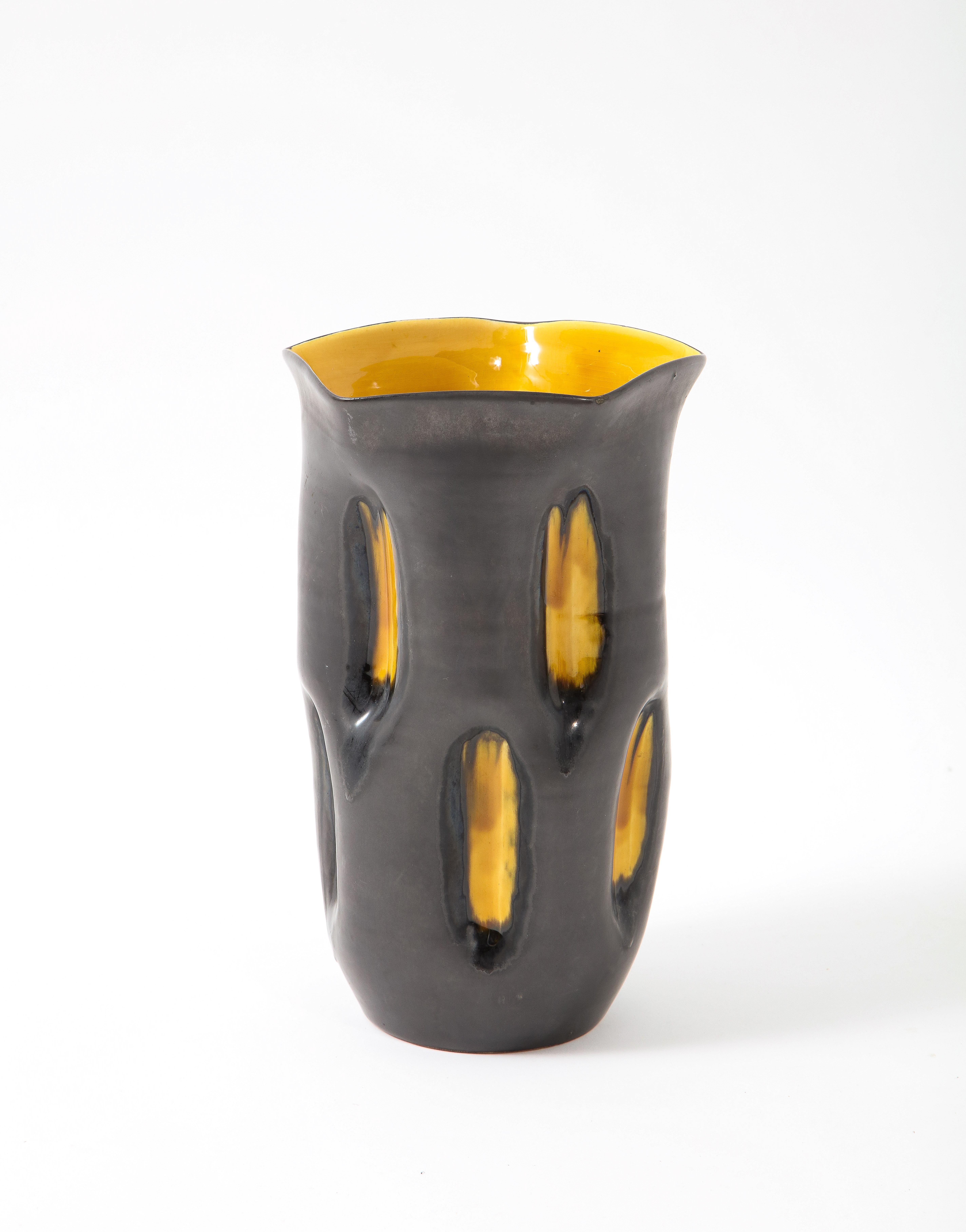 Vase fantaisiste en céramique avec une glaçure à deux tons, gris canon de fusil pour le corps et jaune brillant pour les creux de la surface et de l'intérieur.