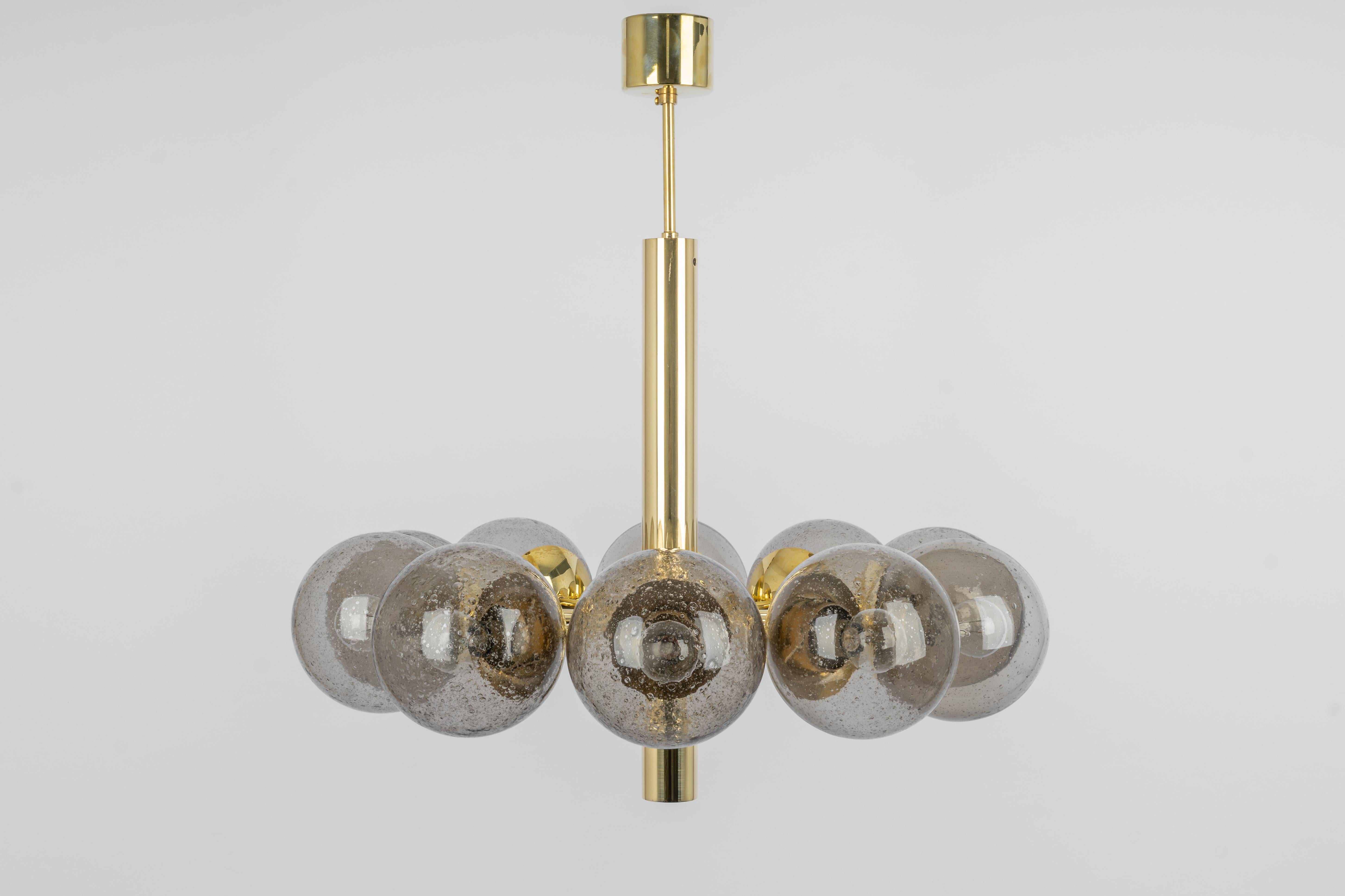 Stunning radial Sputnik brass color chandelier with ten smoked glass globes by Kaiser Leuchten, Germany, 1960s.
High quality and in very good condition. Cleaned, well-wired and ready to use.
The fixture requires 10 x E14 small bulbs with 40W max