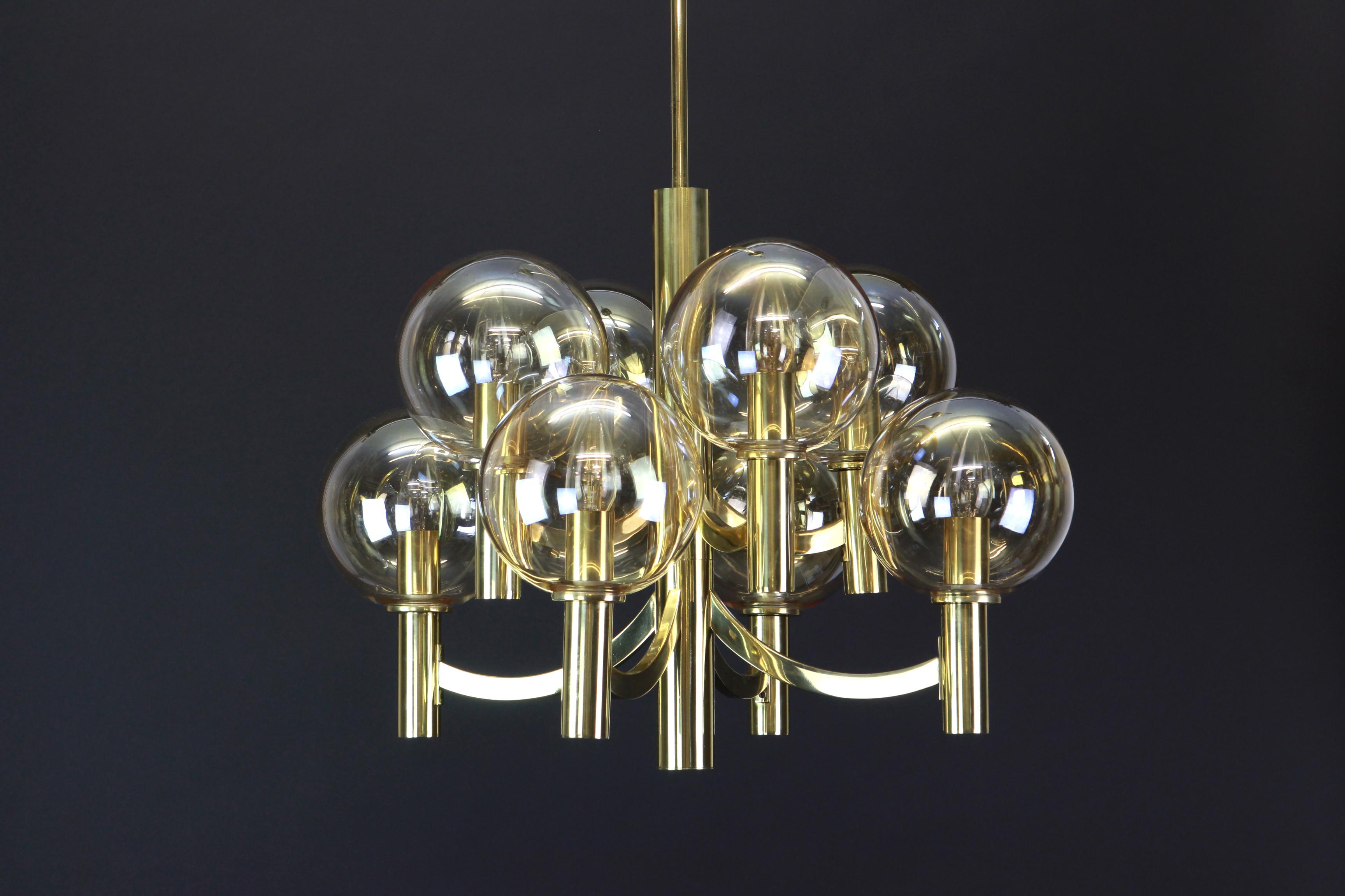 Stunning Sputnik brass chandelier with eight smoked glass globes by Kaiser Leuchten, Germany, 1960s.

Heavy quality and in very good condition. Cleaned, well-wired and ready to use. 

The fixture requires eight E14 Small bulbs with 40W max each