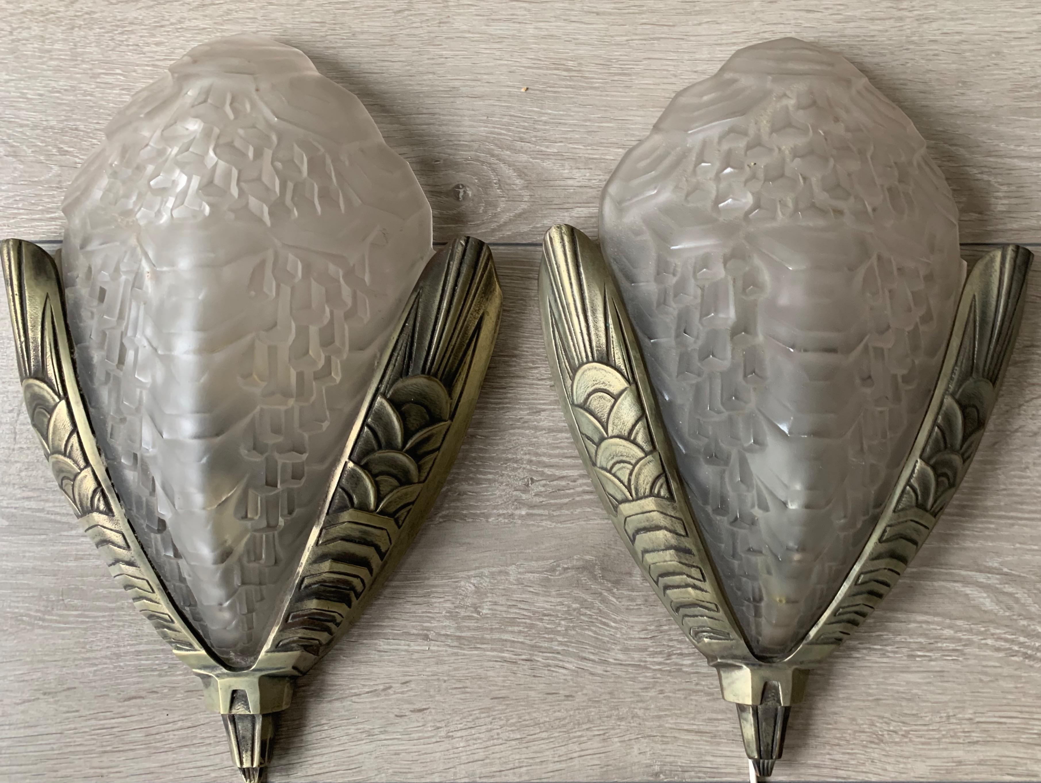 Impressive pair of bronze wall lights with perfect glass shades.

If you are looking for a pair of beautiful and good quality Art Deco wall sconces then these striking lights should be on your shortlist. Both in design and execution these Art Deco
