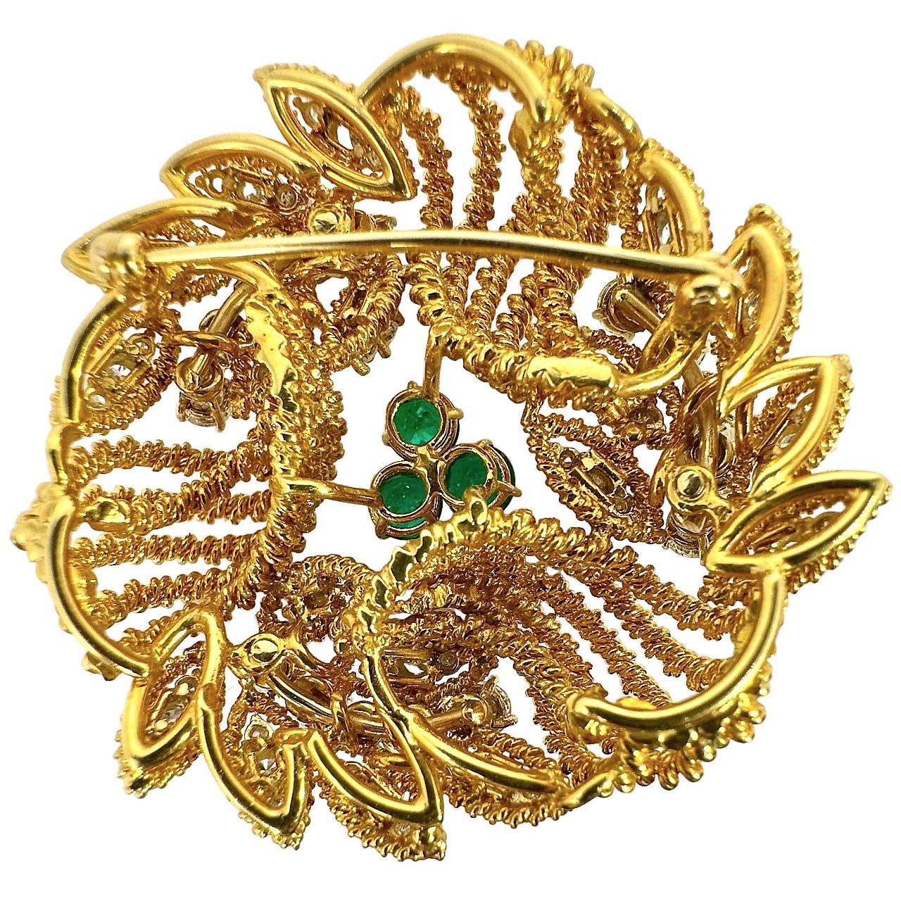 This wonderful and visually exciting Mid-20th Century 18k yellow gold brooch,  is a perfect blending  of hand crafting with fine diamonds and emeralds. Every surface is produced by pulling or twisting 18k gold wire and, the effect is sensational.
