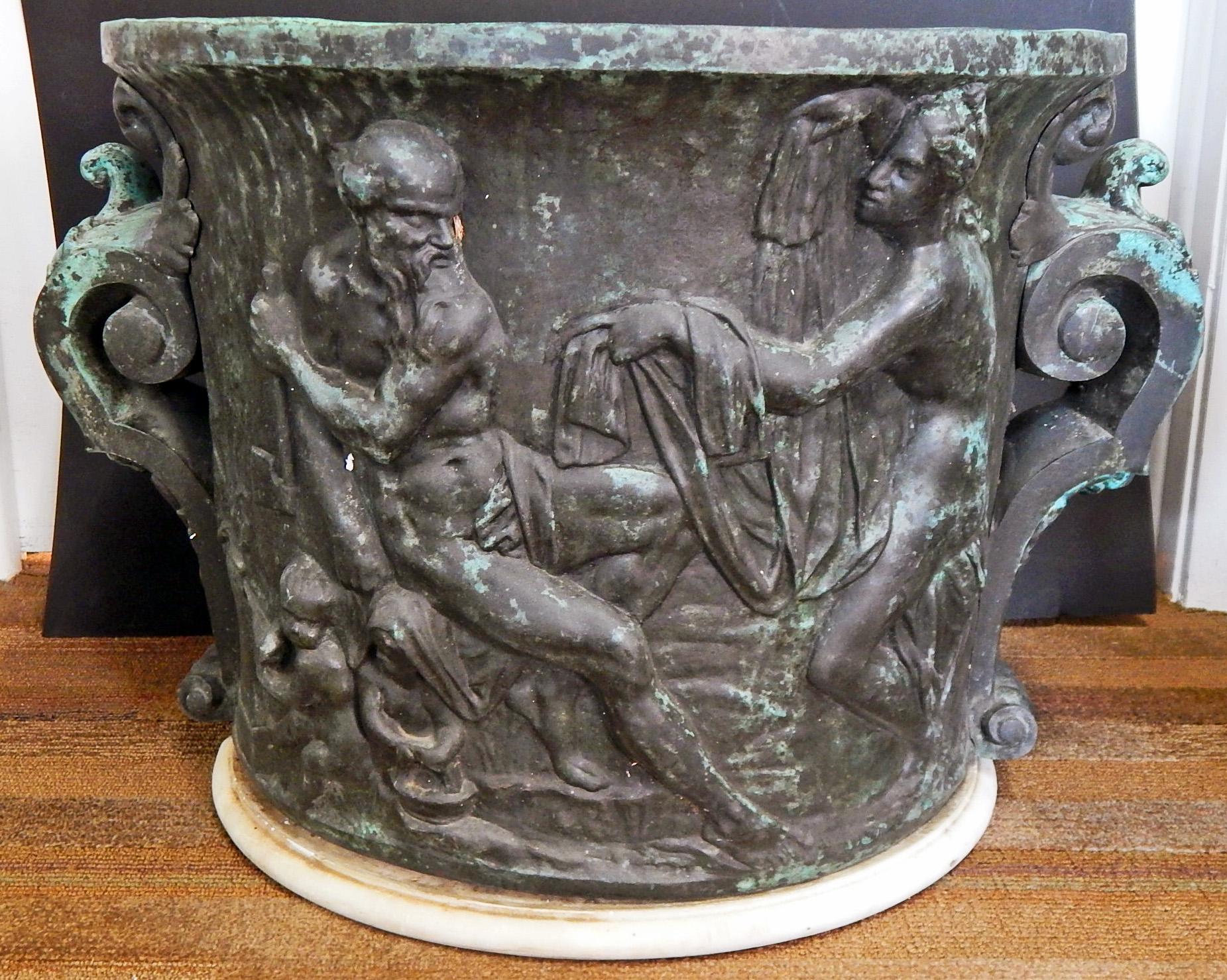 Beautifully sculpted and cast, this large and remarkable bronze urn is enlivened with a series of nude mythological figures in bas relief, the dark bronze color highlighted with areas of verdigris, indicating that it sat in an outdoor garden. The