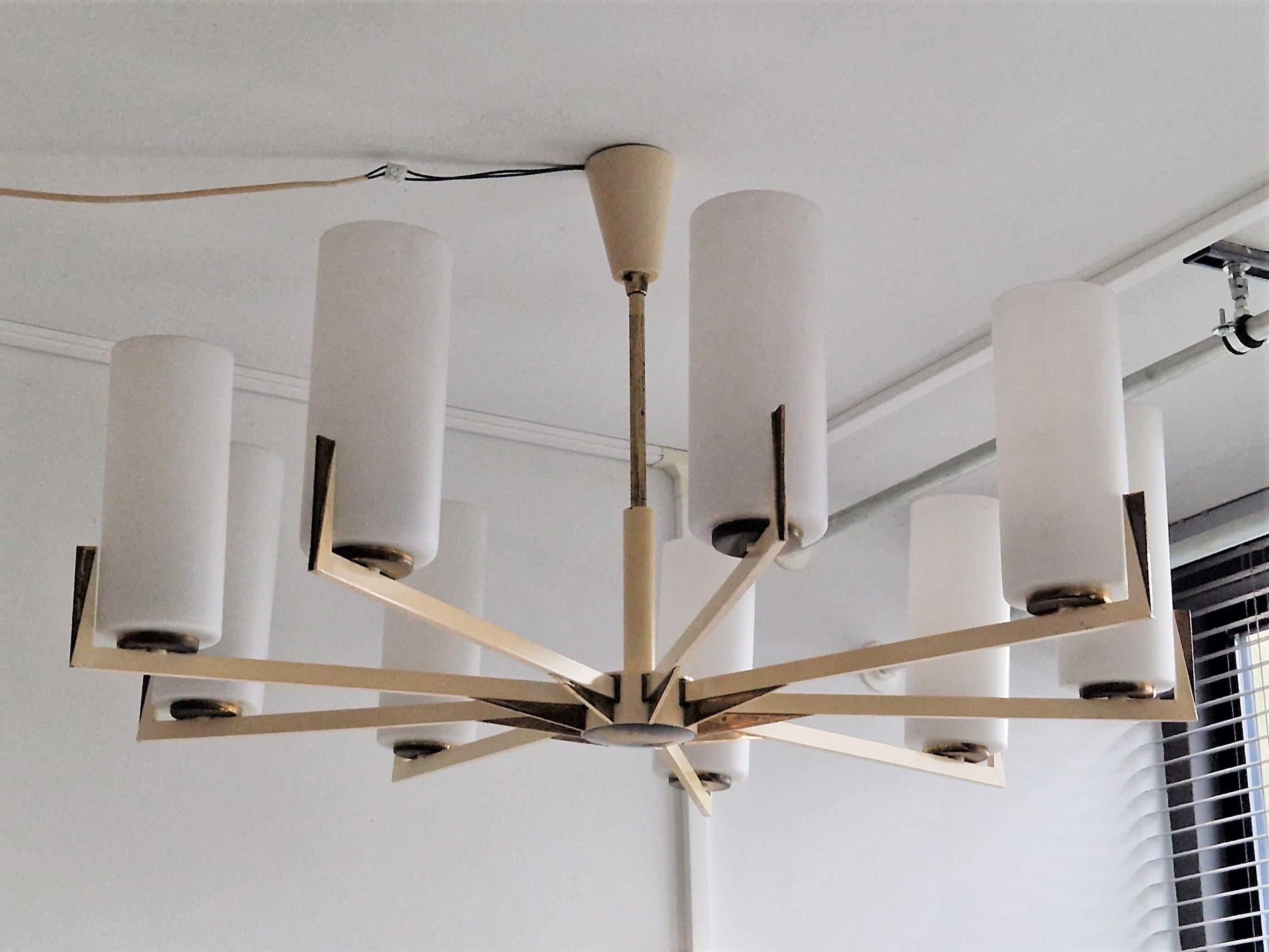 This is a very impressive chandelier with brass and cream white lacquered arms holding 9 opaline glass tubes that gives a beautiful diffused illumination. It is very likely a German design, made in the 1950's. A very modern and timeless design of