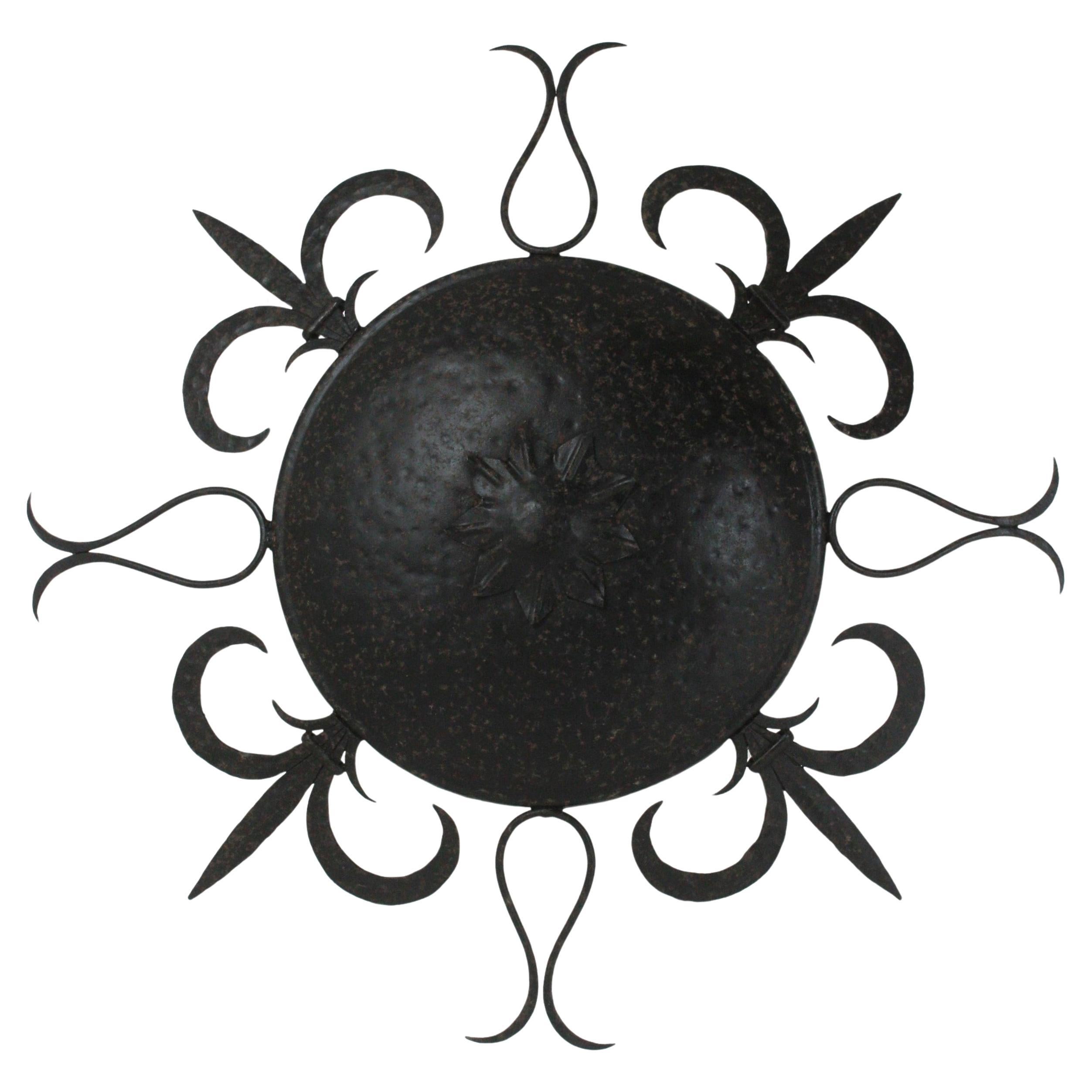 Black Patinated Sunburst Ceiling Light, Wrought iron, France, 1950s.
This monumental ceiling flush mount is entirely made in hand-forged iron. Original finish in black color with terrific rusty aged patina.
The central sphere is surrounded by