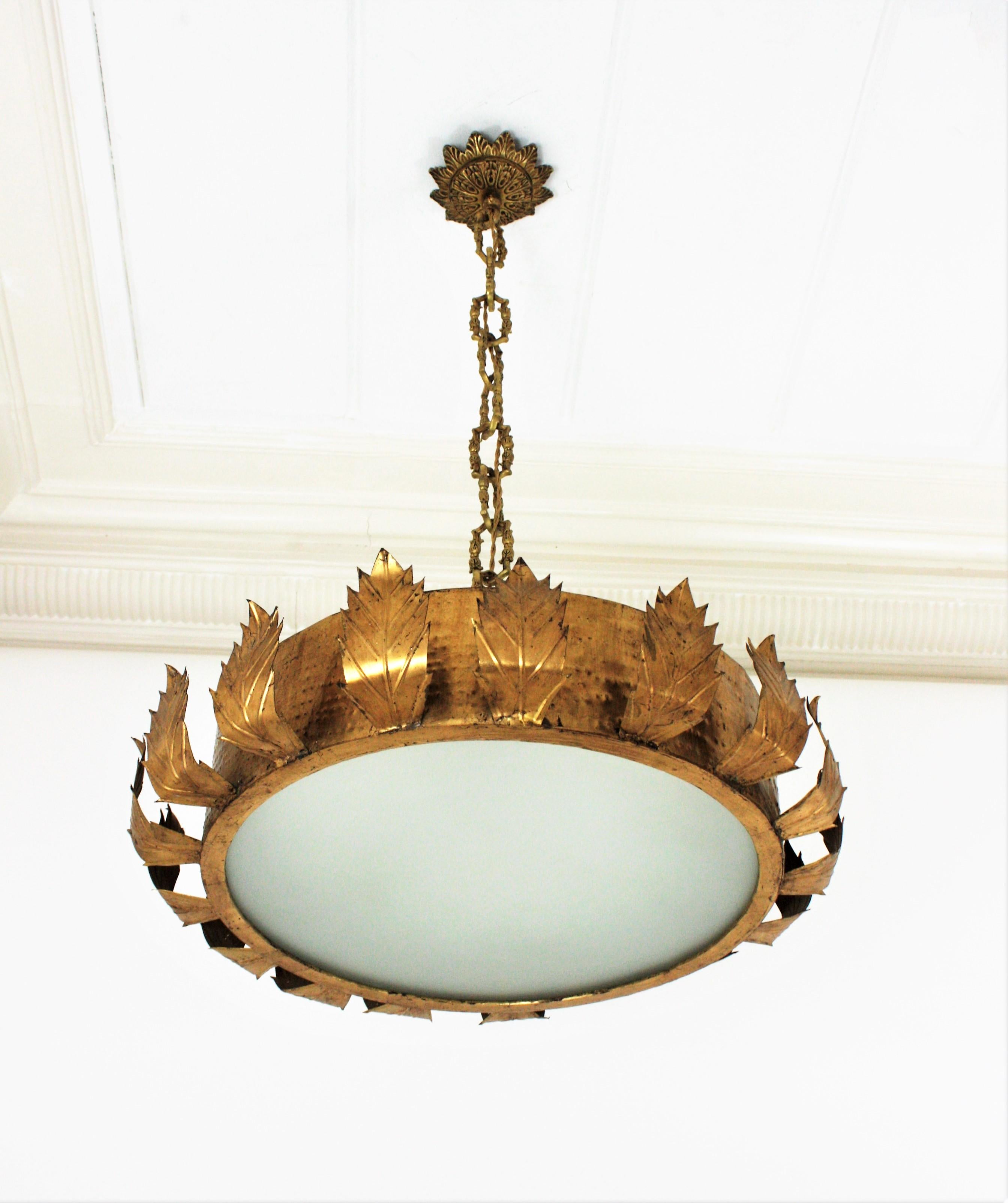 Gilt iron and bronze sunburst crown shape chandelier or ceiling light fixture with frosted glass, Spain, 1950s.
This ceiling light was handcrafted in Spain at the Mid-Century Modern period in the style of Brutalism. The body of the light fixture is