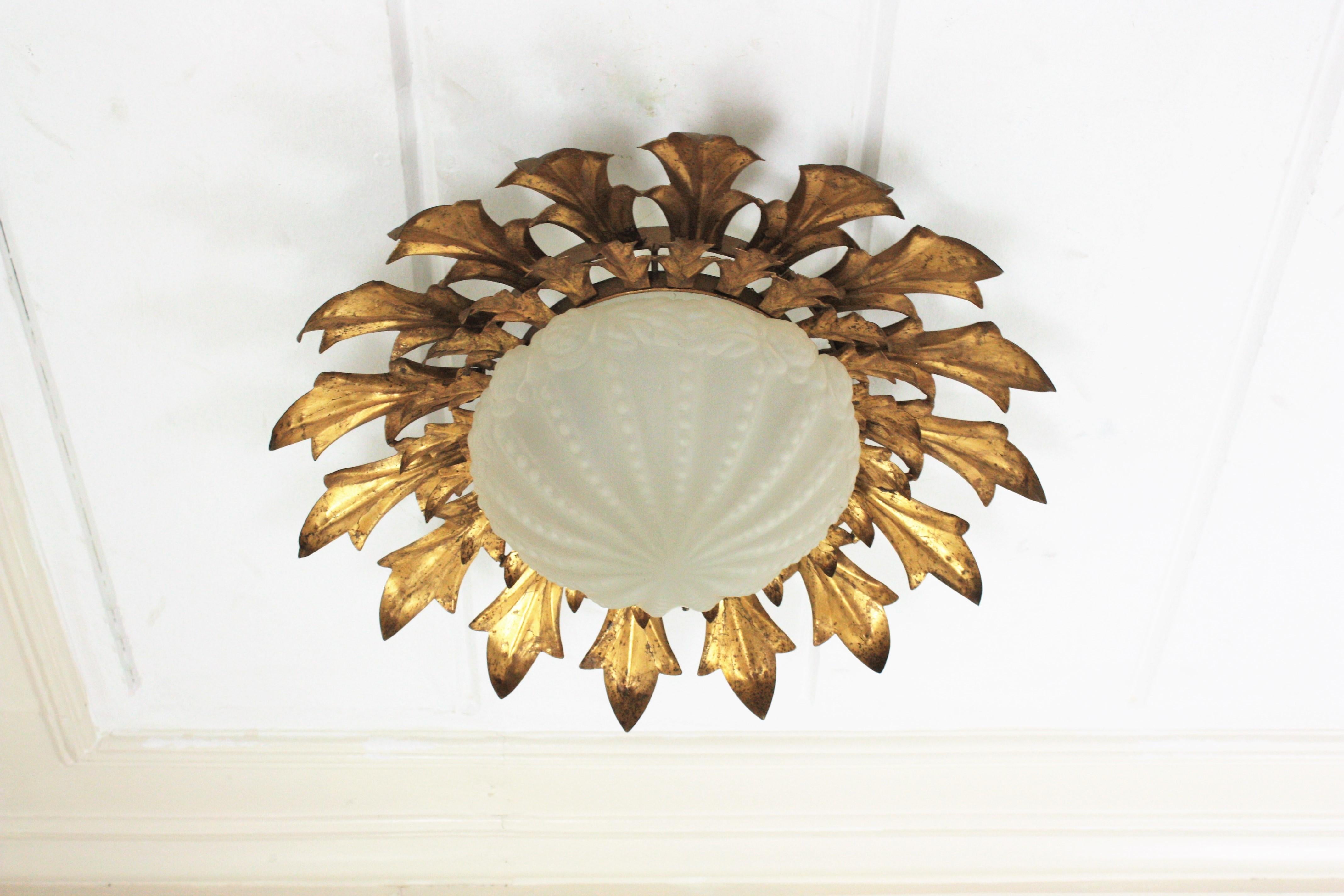 Hollywood Regency Large Sunburst Flush Mount in Gilt Iron with Frosted Glass Globe For Sale