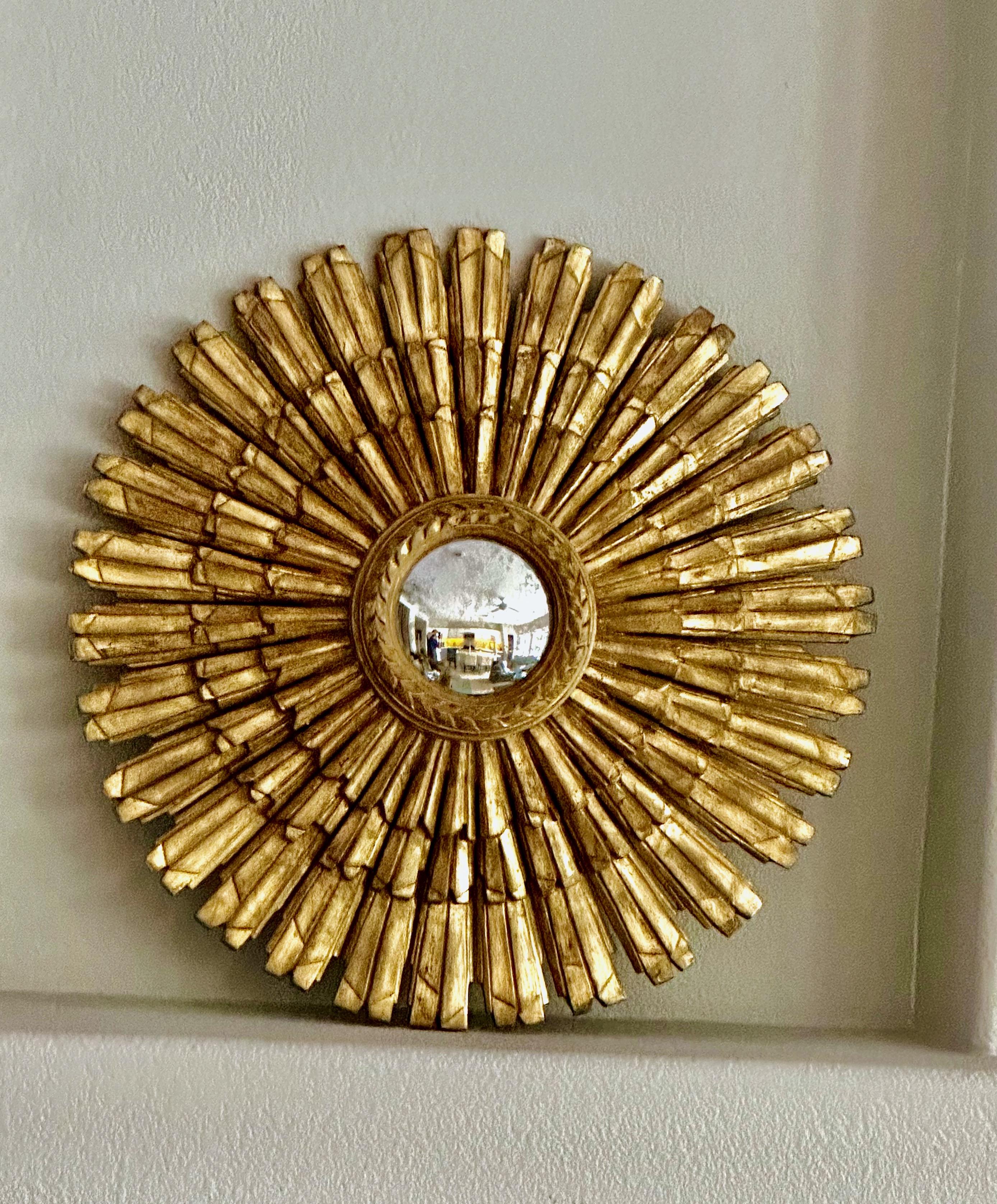 Miroir mural en bois doré sculpté en forme de soleil ou d'étoile avec miroir convexe vieilli inséré, réalisé par Palladio en Italie. Diamètre du miroir 5.25
