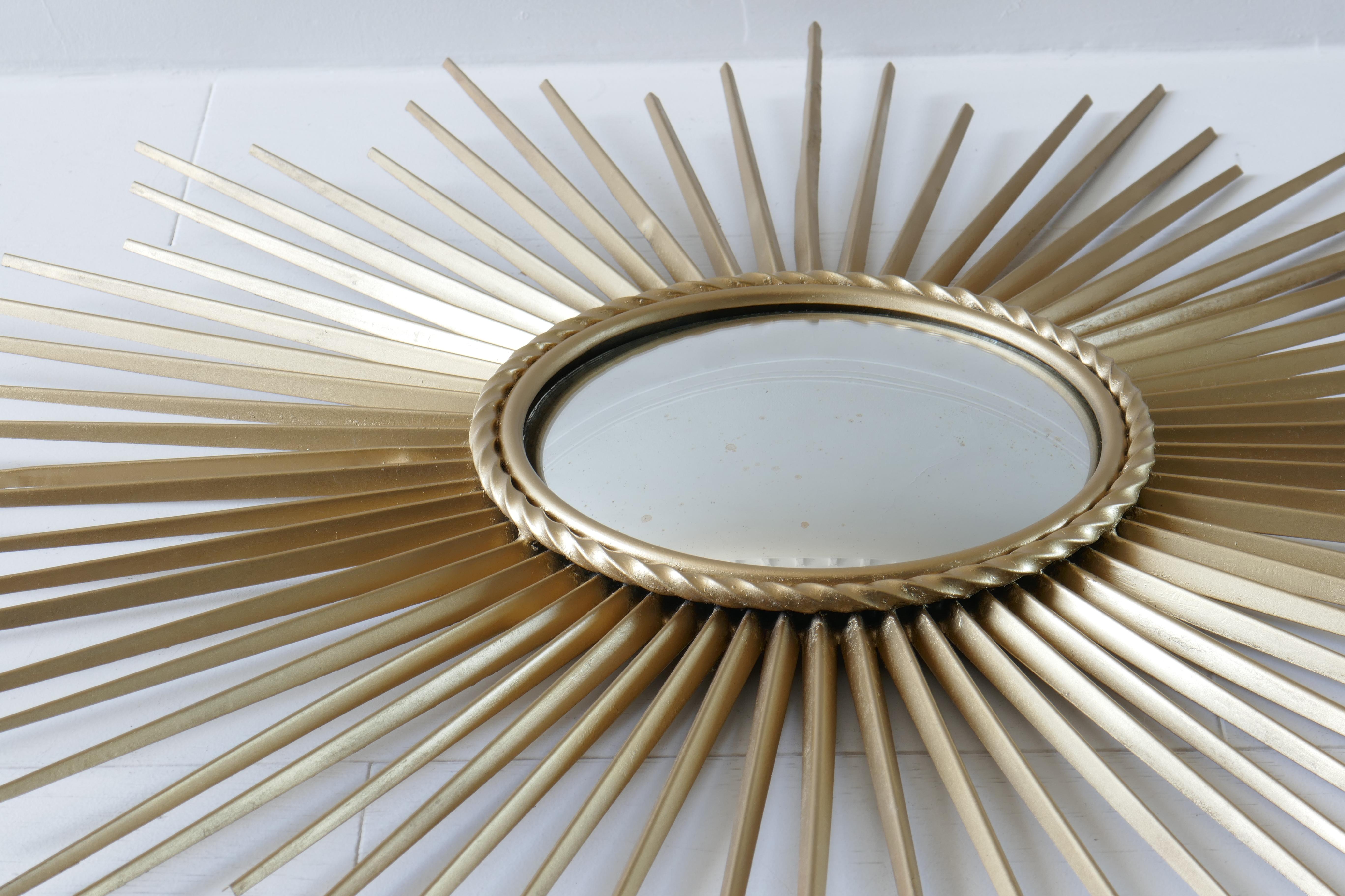 Large sunburst convex mirror by Chaty Vallauris. Stunning handcrafted iron overlaid in brass finish.
Central mirror is 9 inches whilst the frame is 25.5 inches.
Signed in the back. 
France,1960s.