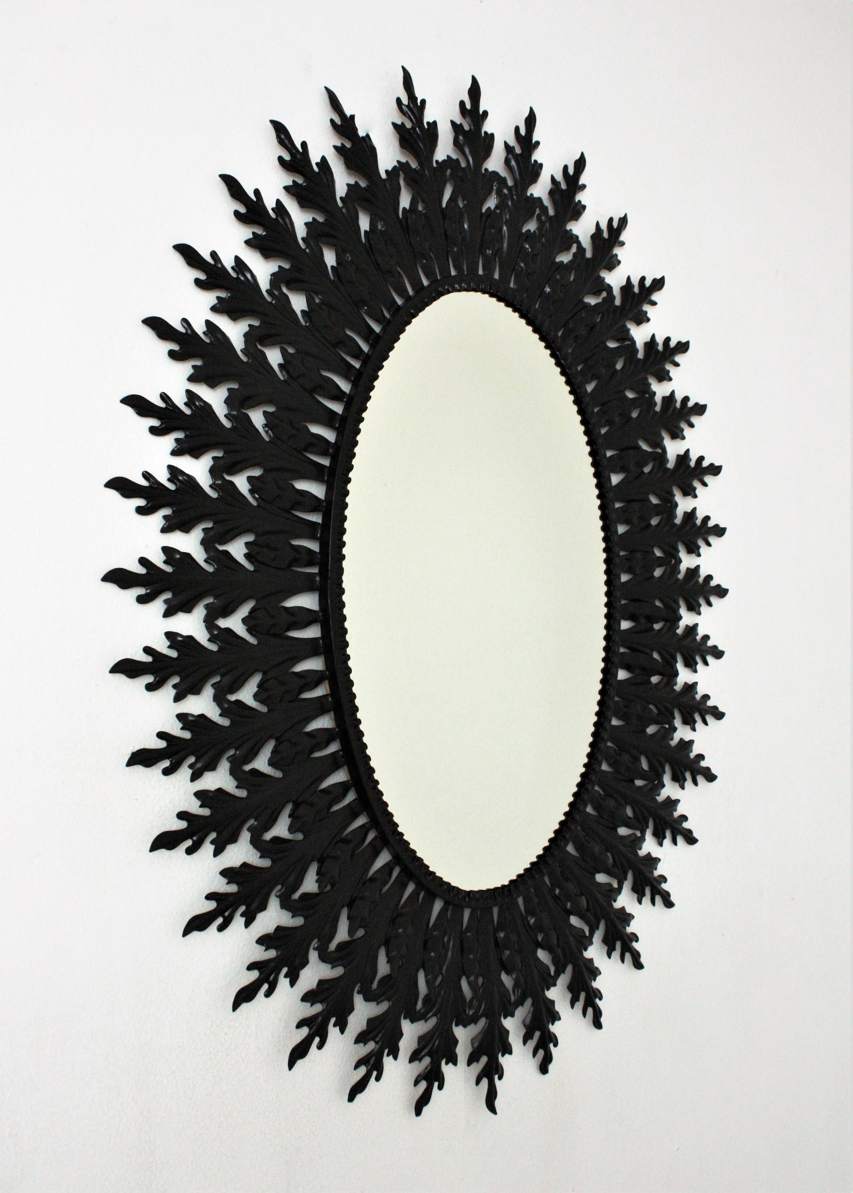 Mid-Century Modern Grand miroir ovale Sunburst en fer laqué noir en vente