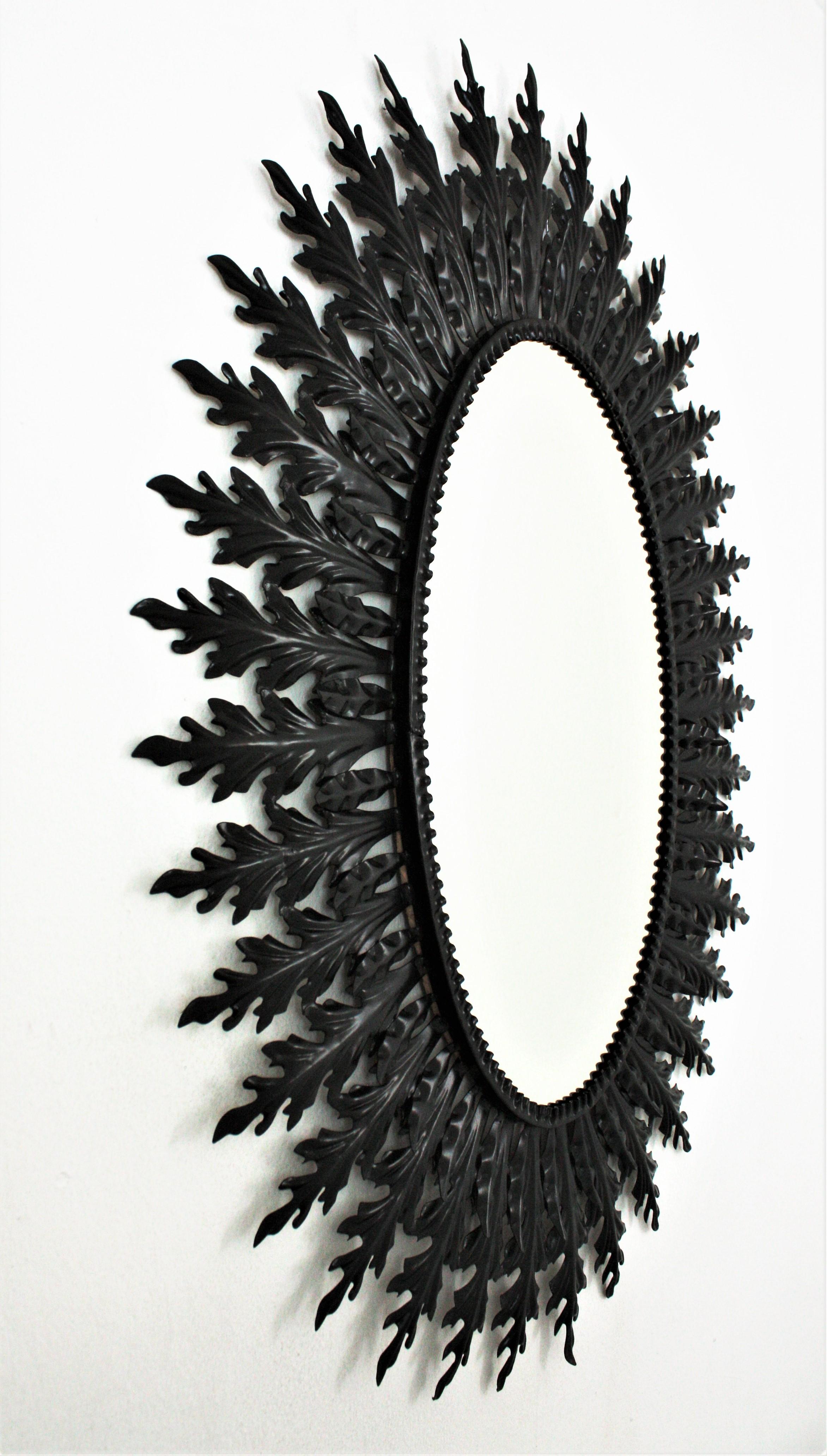 Espagnol Grand miroir ovale Sunburst en fer laqué noir en vente