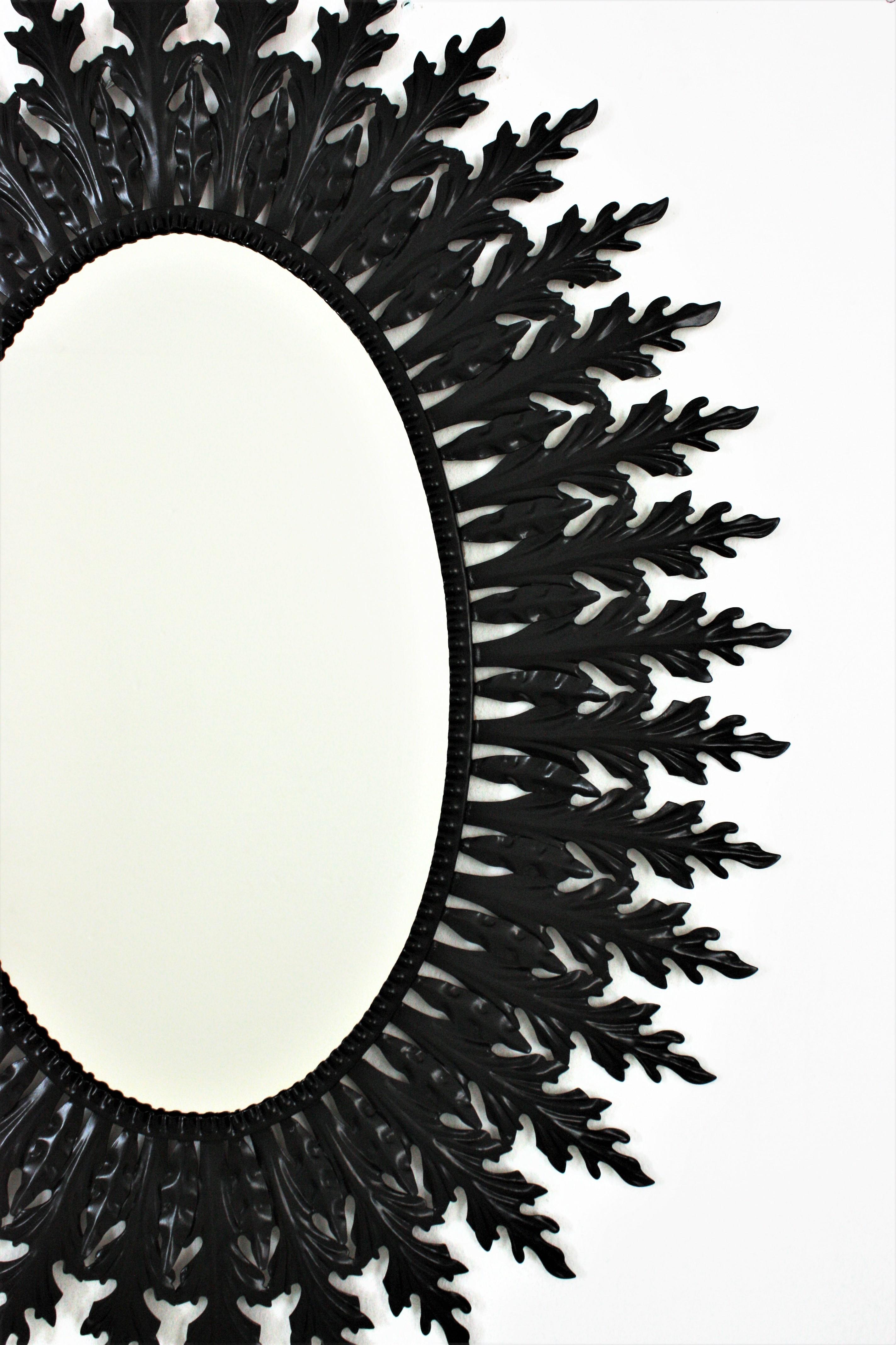 20ième siècle Grand miroir ovale Sunburst en fer laqué noir en vente