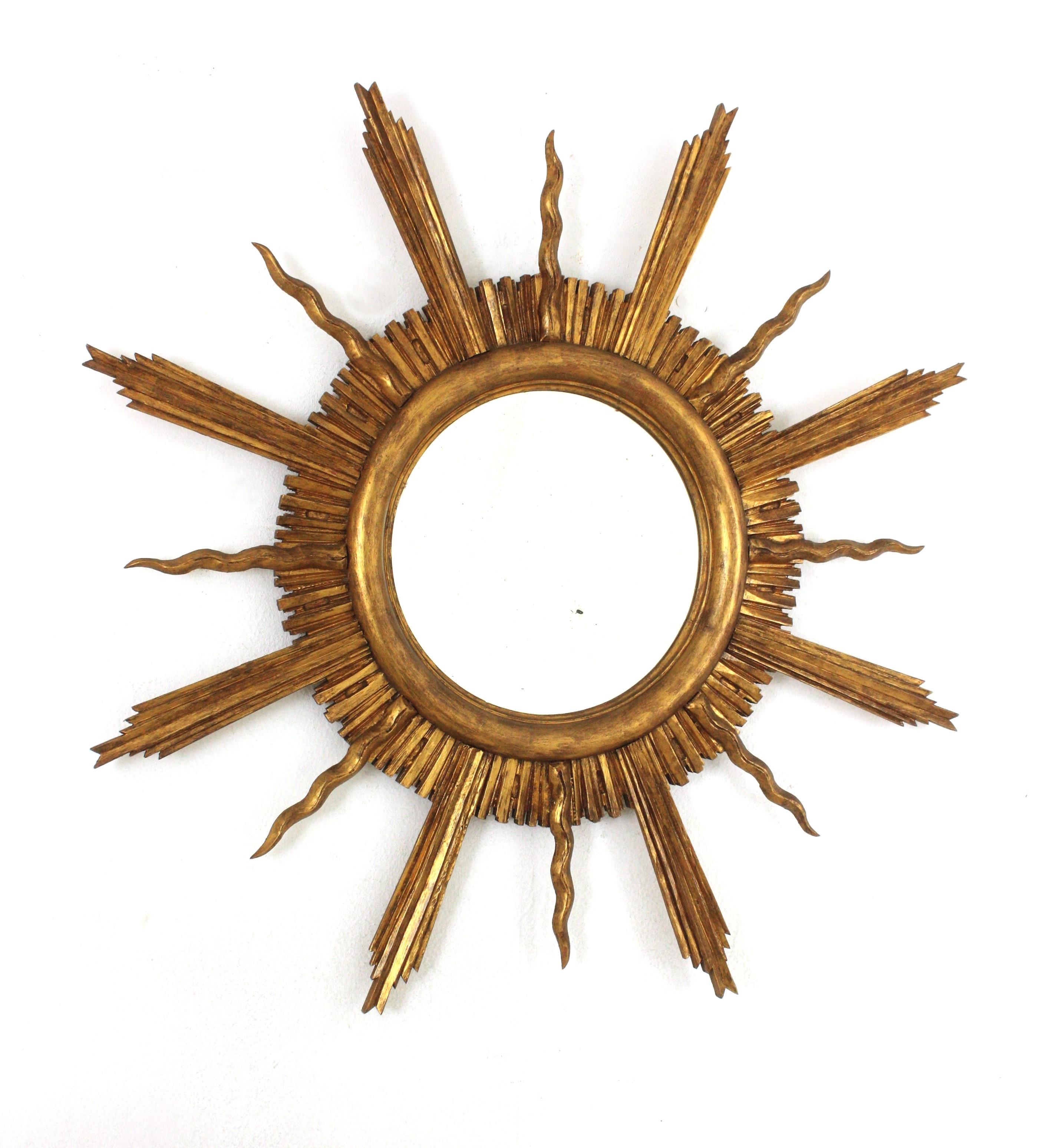 Outstanding carved giltwood sunburst starburst mirror, France, 1930s-1940s.
Large gilded sunburst mirror with design reminiscences in the manner of Gilbert Poillerat.
French Modern Neoclassical with Baroque style accents.
This sunburst mirror