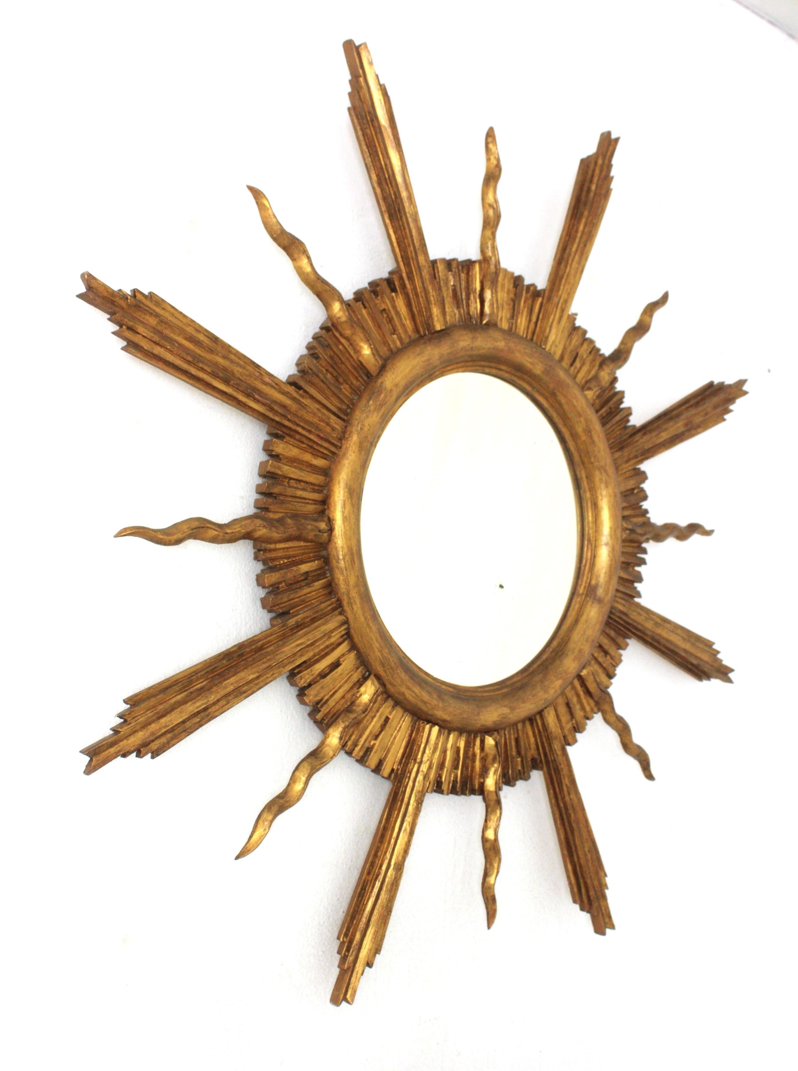 French Large Sunburst Starburst Giltwood Mirror in the Style of Gilbert Poillerat For Sale