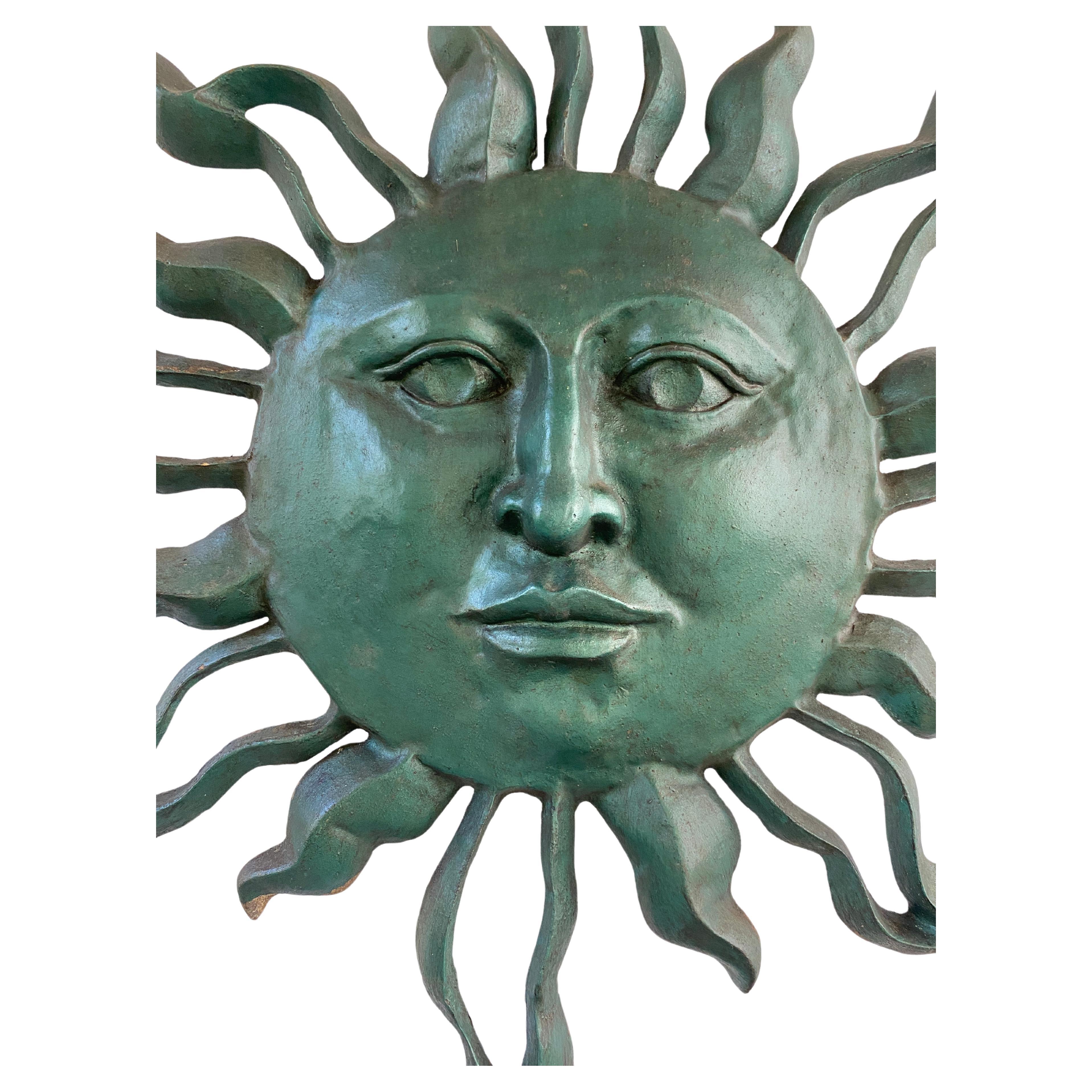 Make a bold statement indoors or outdoors with this eye-catching sunburst wall sculpture. Crafted from polished aluminum and finished in a striking forest green, the sculpture features a distressed texture that adds depth and character. Its dynamic,