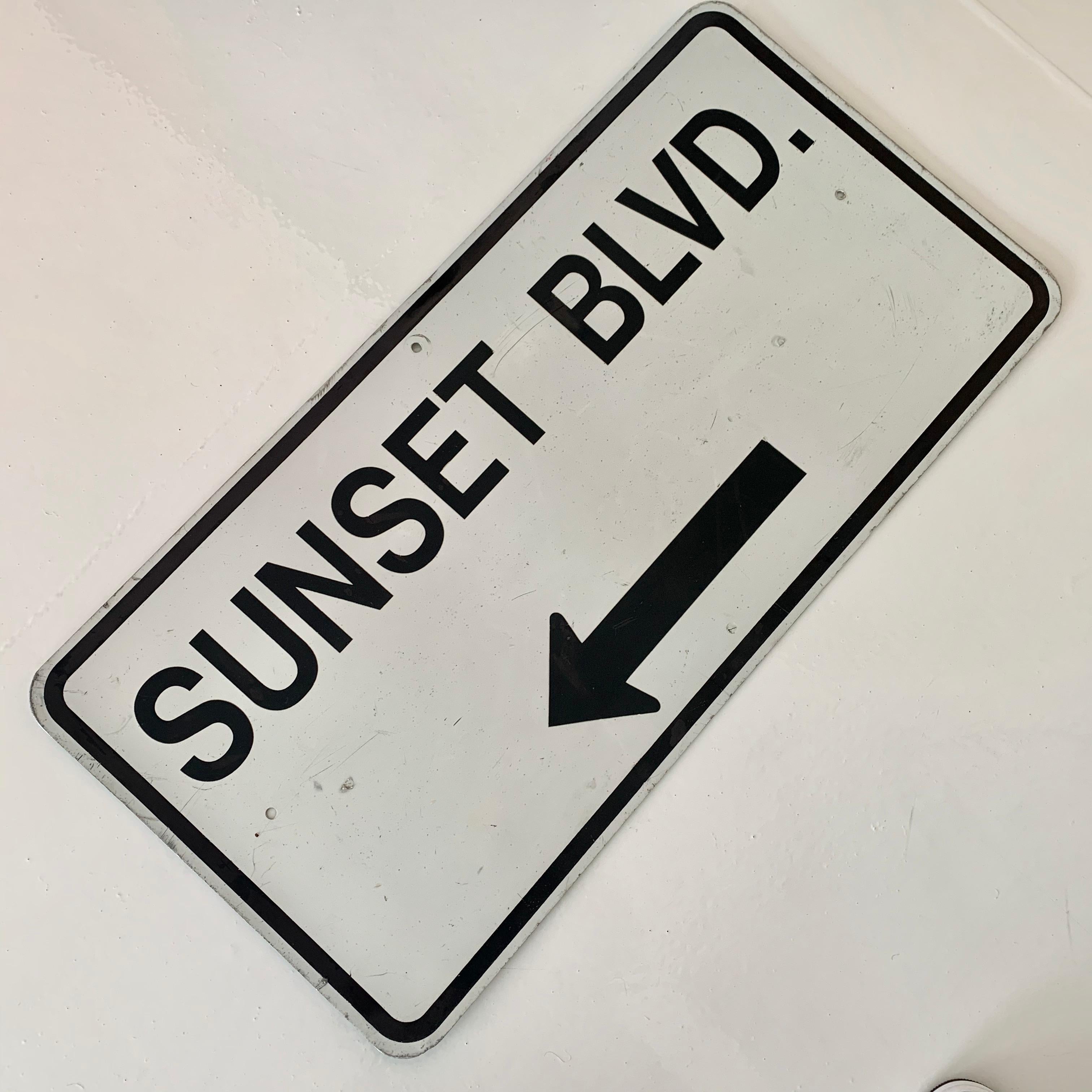 Cool street sign from Sunset Blvd in Los Angeles. White sign with black lettering, circa 1980s. Measures: 3 feet long by 18 inches tall. Fun piece of Los Angeles/California transportation ephemera.
  