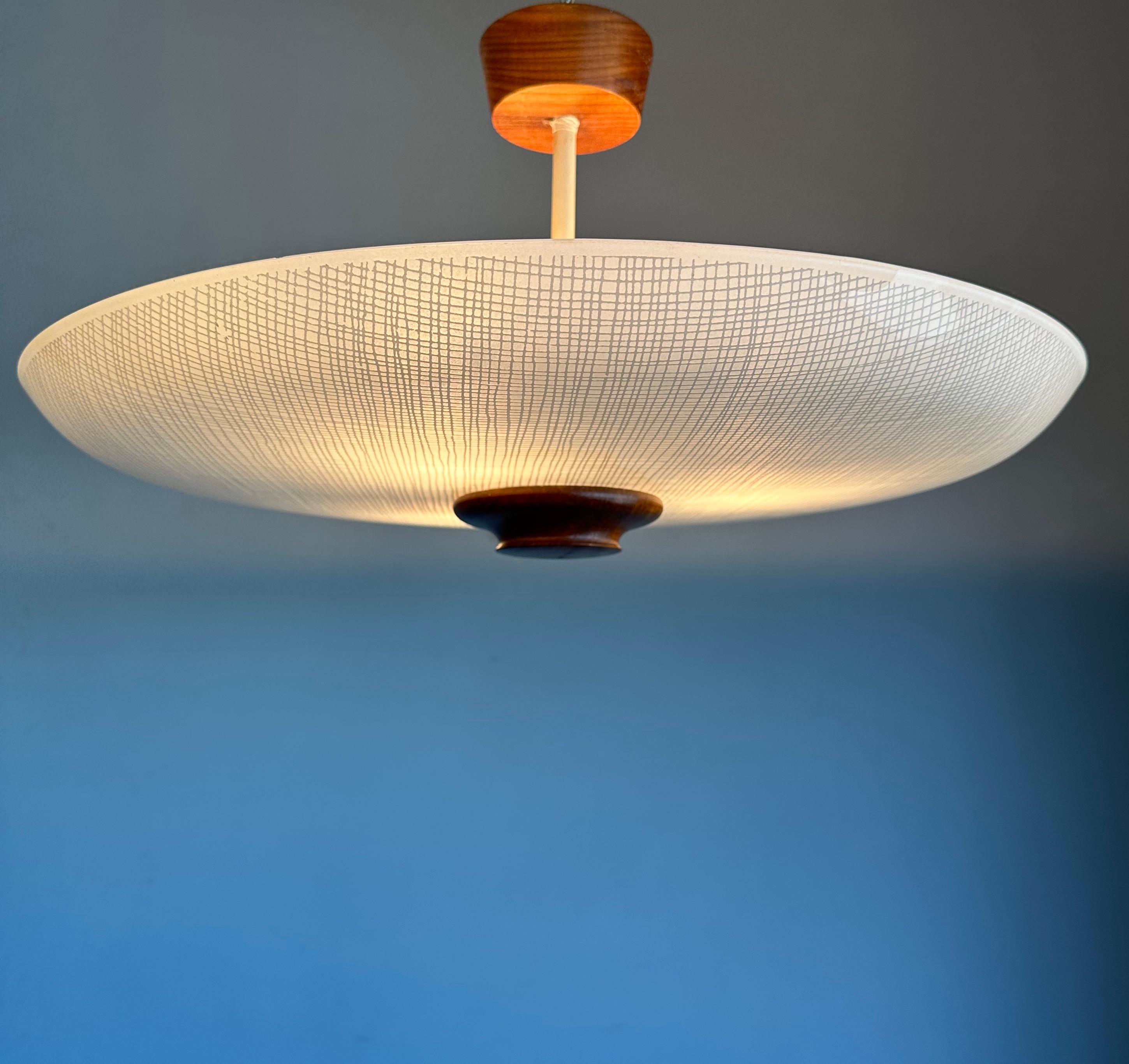 Great Mid-Century Modern ceiling light with teakwood finial & canopy and 'woven' stripes pattern in the glass shade.

This vintage, three-light flush mount has a beautiful look and feel and you will hardly ever find a light fixture from the