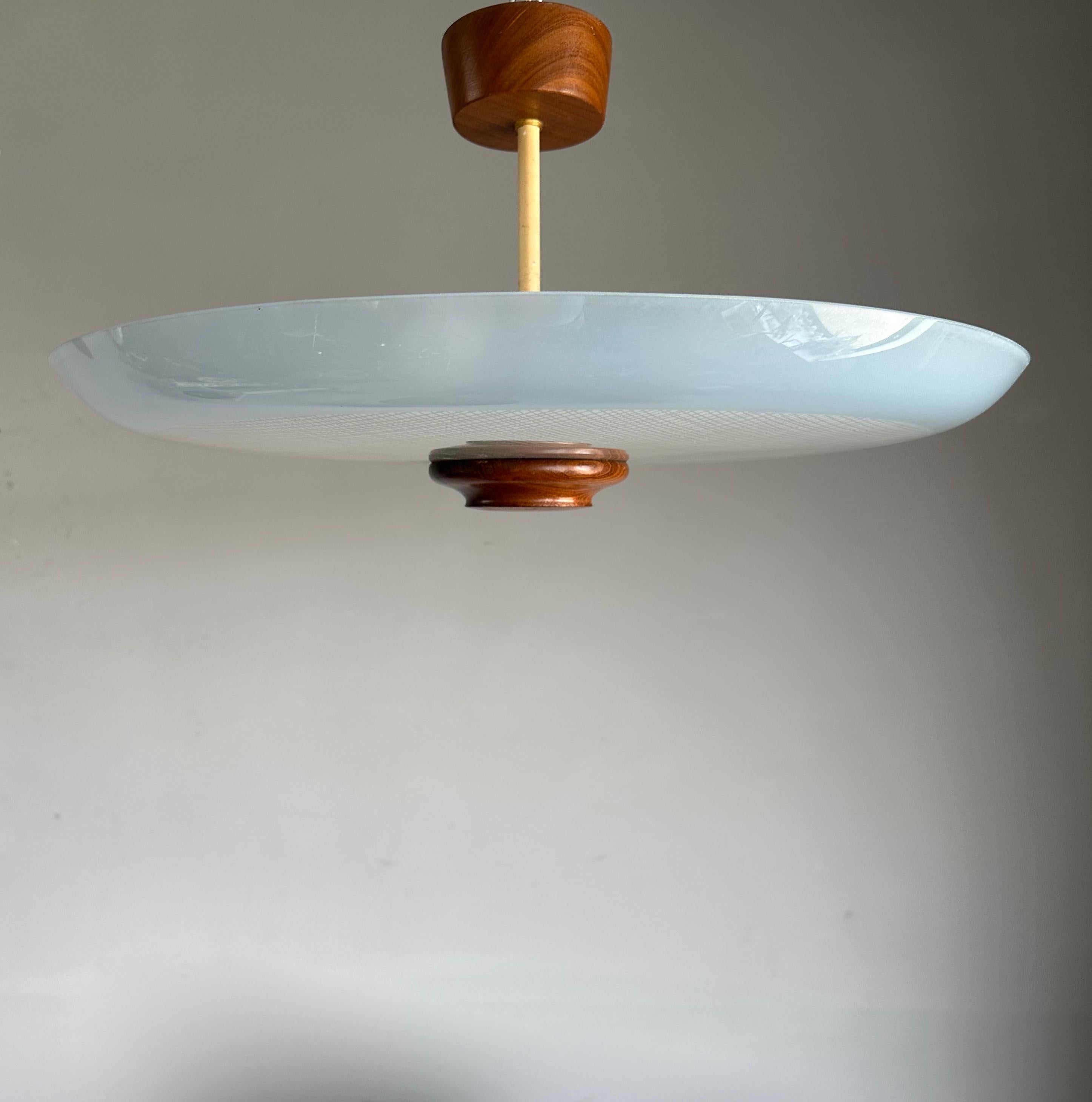 Great Mid-Century Modern ceiling light with teakwood finial & canopy and 'woven' stripes pattern in the glass shade.

This vintage, three-light flush mount has a beautiful look and feel and you will hardly ever find a light fixture from the