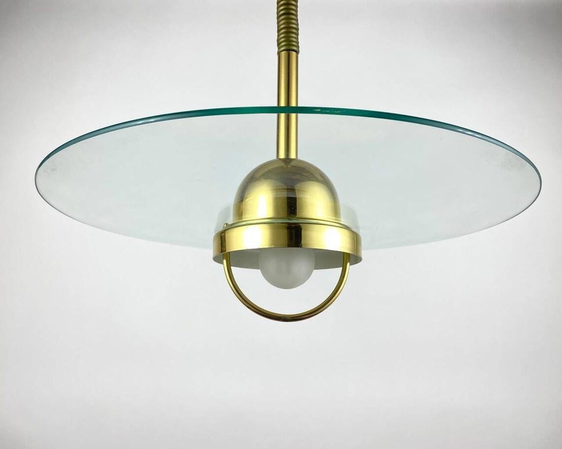 Large Vintage chandelier in modern style. Germany, 1980s.

German glass disk light featuring the brass light source housing with a diffuser surrounded by a glass plate.

All suspended on the steel wire from the round metal ceiling mount.

Very