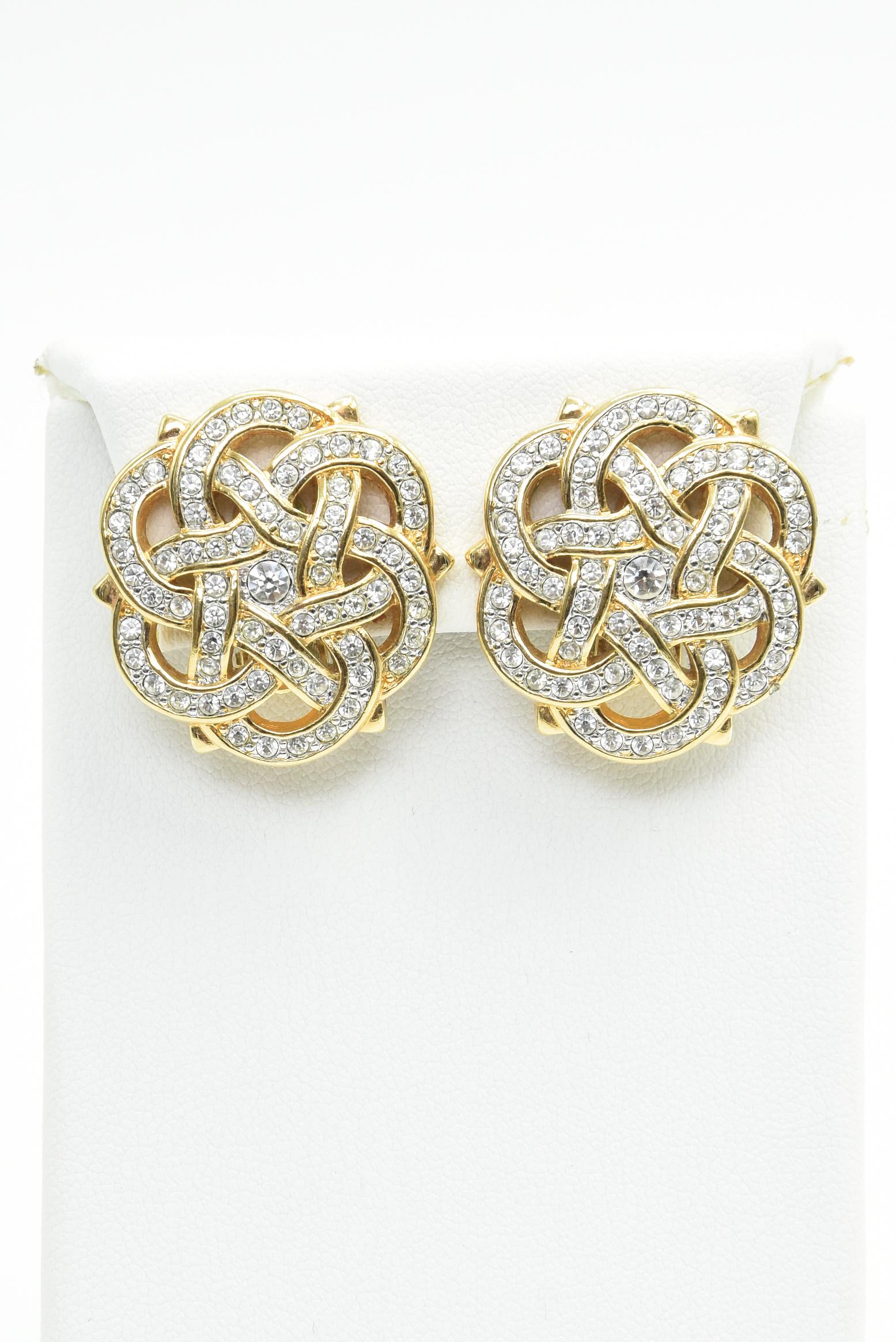 Authentic vintage Swarovski earrings featuring a gold toned Celtic knot or ribbon design set with Swarovski crystals.  Stunning earrings that clip on for easy use.

They have the swan logo on the back where the clip clamps down.  