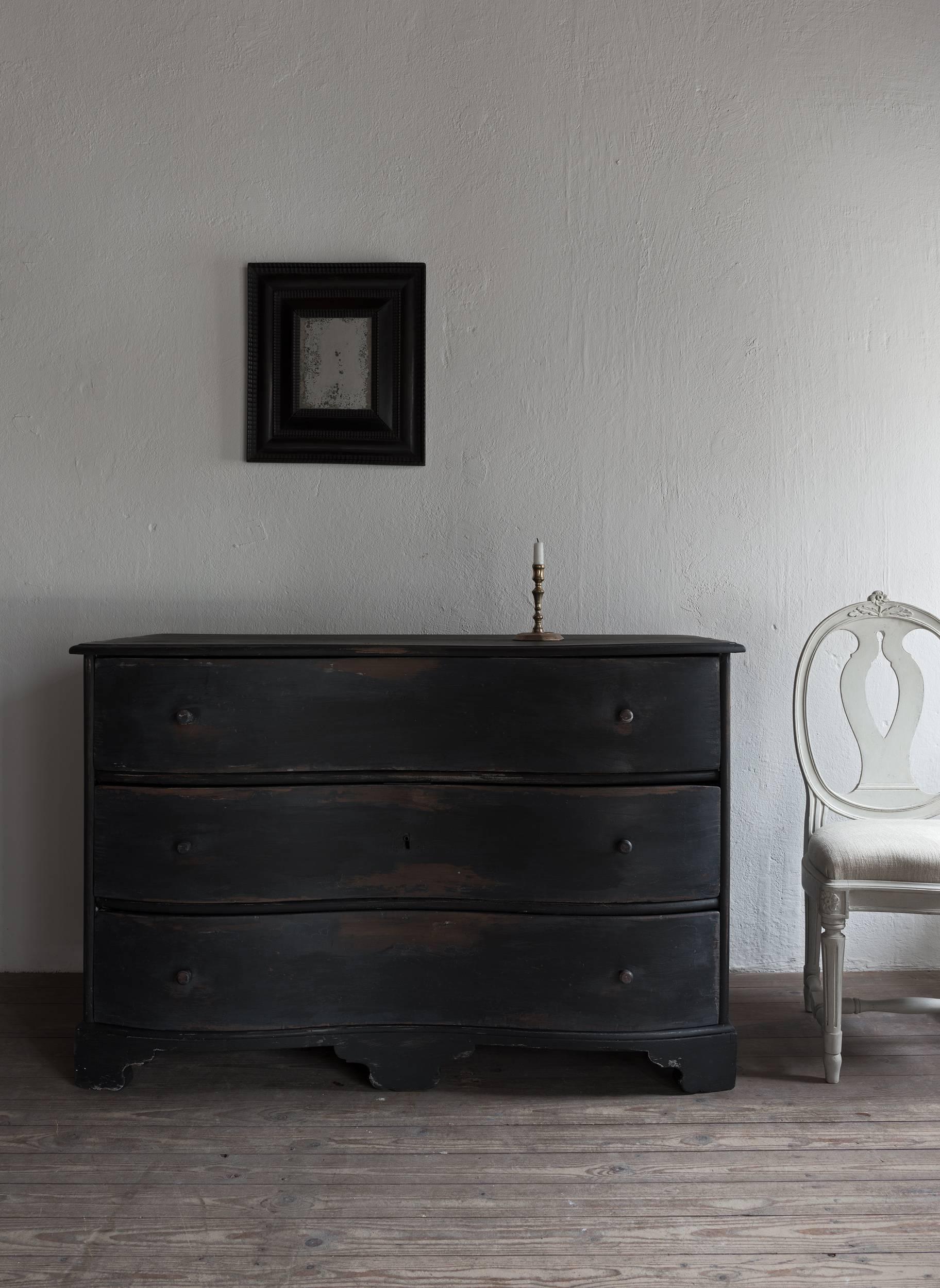 Beautiful soft lined 18th century chest of drawers. Black, distressed paint, retouched. Original chamfered 18th century back and triple lock (one lock closes all drawers).
 