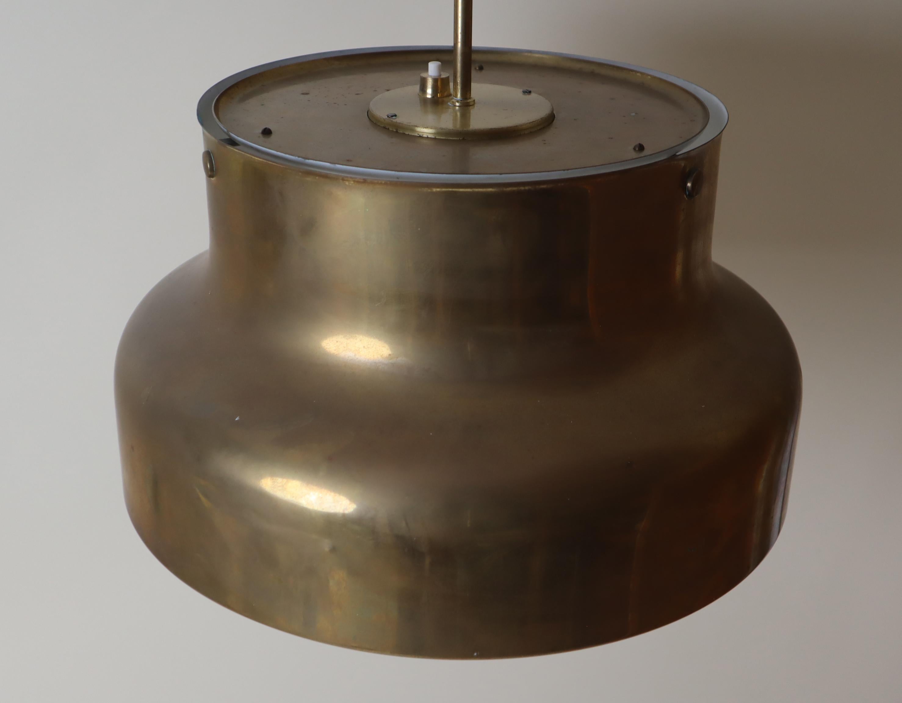 Cette jolie lampe suspendue suédoise est un véritable bijou, avec sa riche histoire et la belle patine naturelle du laiton. Il s'agit d'un véritable classique dans sa première version. Il est un peu usé, mais cela fait partie de son histoire. Je