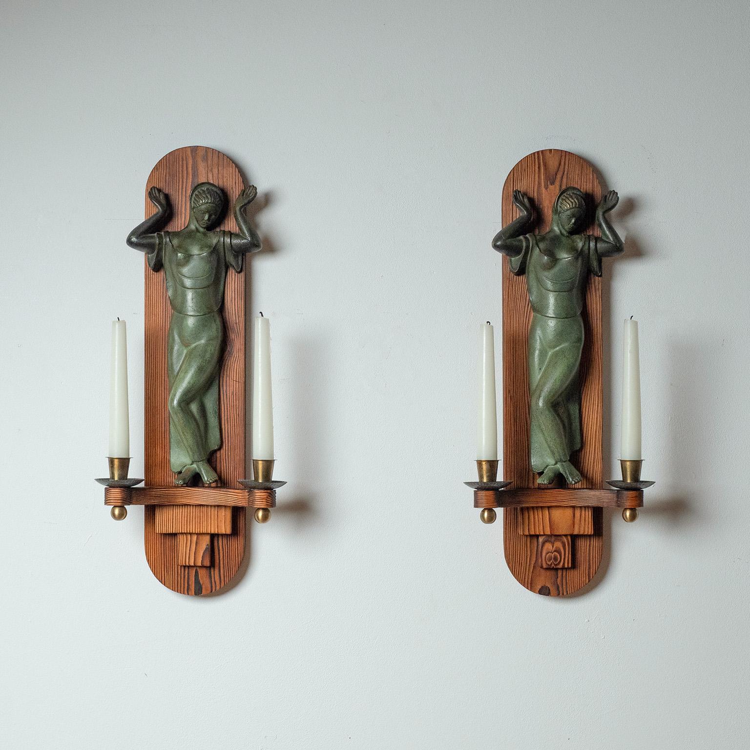 Seltenes Paar großer schwedischer Grace-Kerzenleuchter aus Bronze und Kiefernholz aus den 1930er Jahren, zugeschrieben von Einar Backström. Rückwand aus massivem Kiefernholz mit einer gegossenen und patinierten Bronzefigur. Sehr schöner