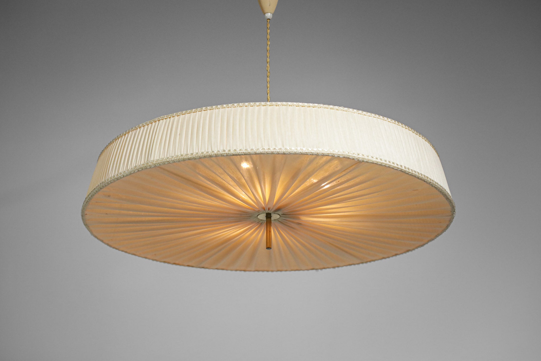 Scandinavian hanging lamp from the 1950s with a rise and fall system in beige lacquered metal with vermiculated paint. Original pleated fabric shade, ceiling attachment and solid brass centre. Very nice detail of the perforated metal star on the top