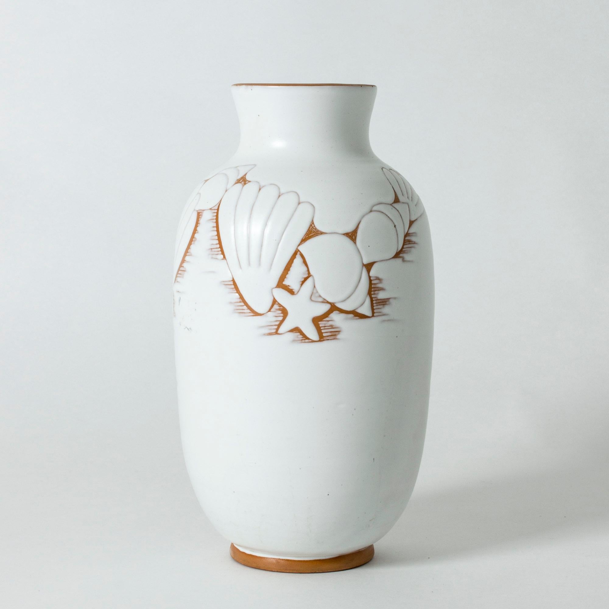 Beautiful, large earthenware vase by Anna-Lisa Thomson. White glaze with a decor of shells and starfish. The contrasting unglazed earthenware emerges in the lines of the decor and around the rim.