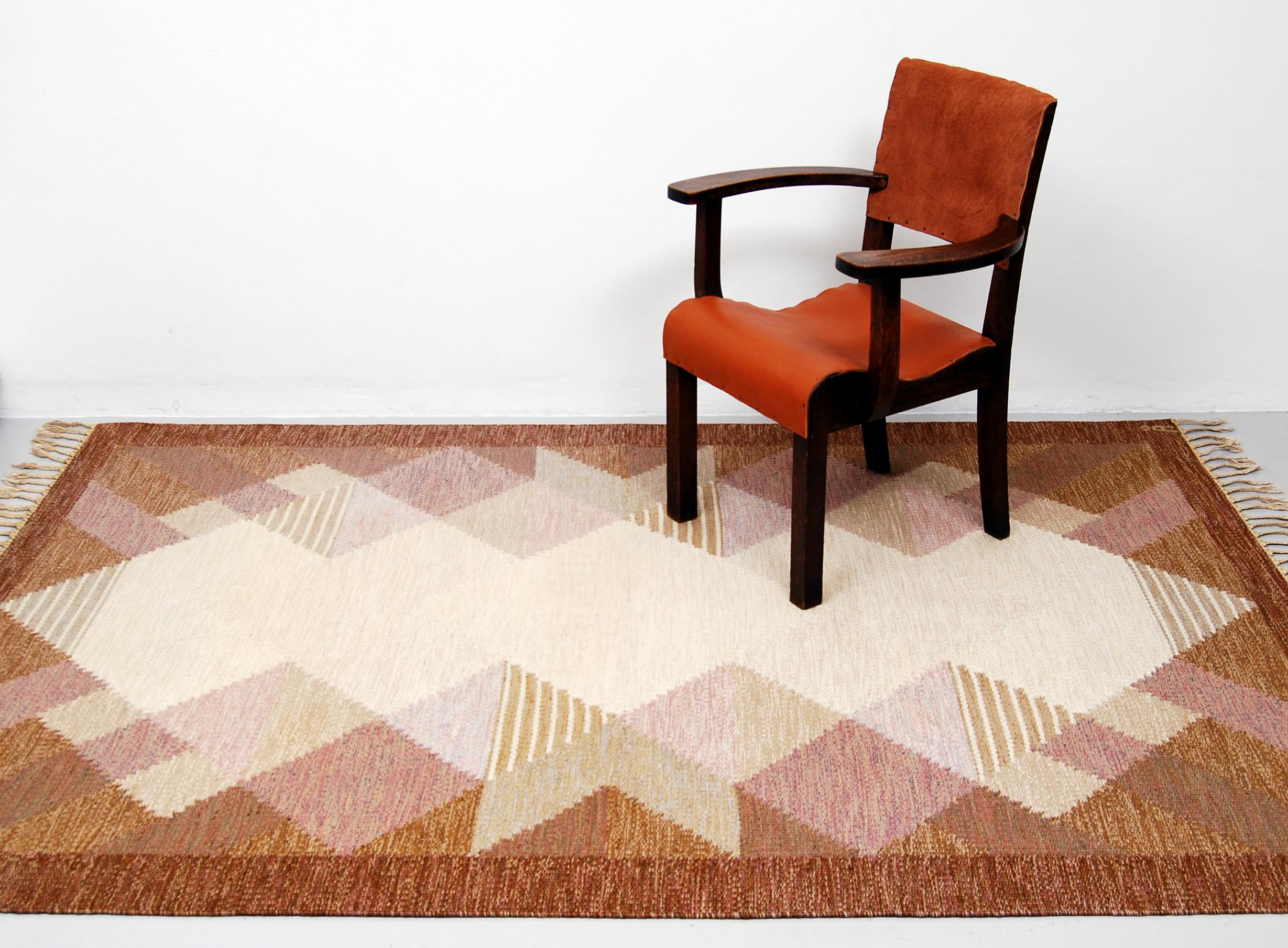 This rölakan carpet / kelim rug ”Aniara” was designed by Anna Johanna Ångström during the 1960s. This example with fields in different shades of brown, purple, beige and grey was woven in wool and signed ”Å” to the right hand corner. Original