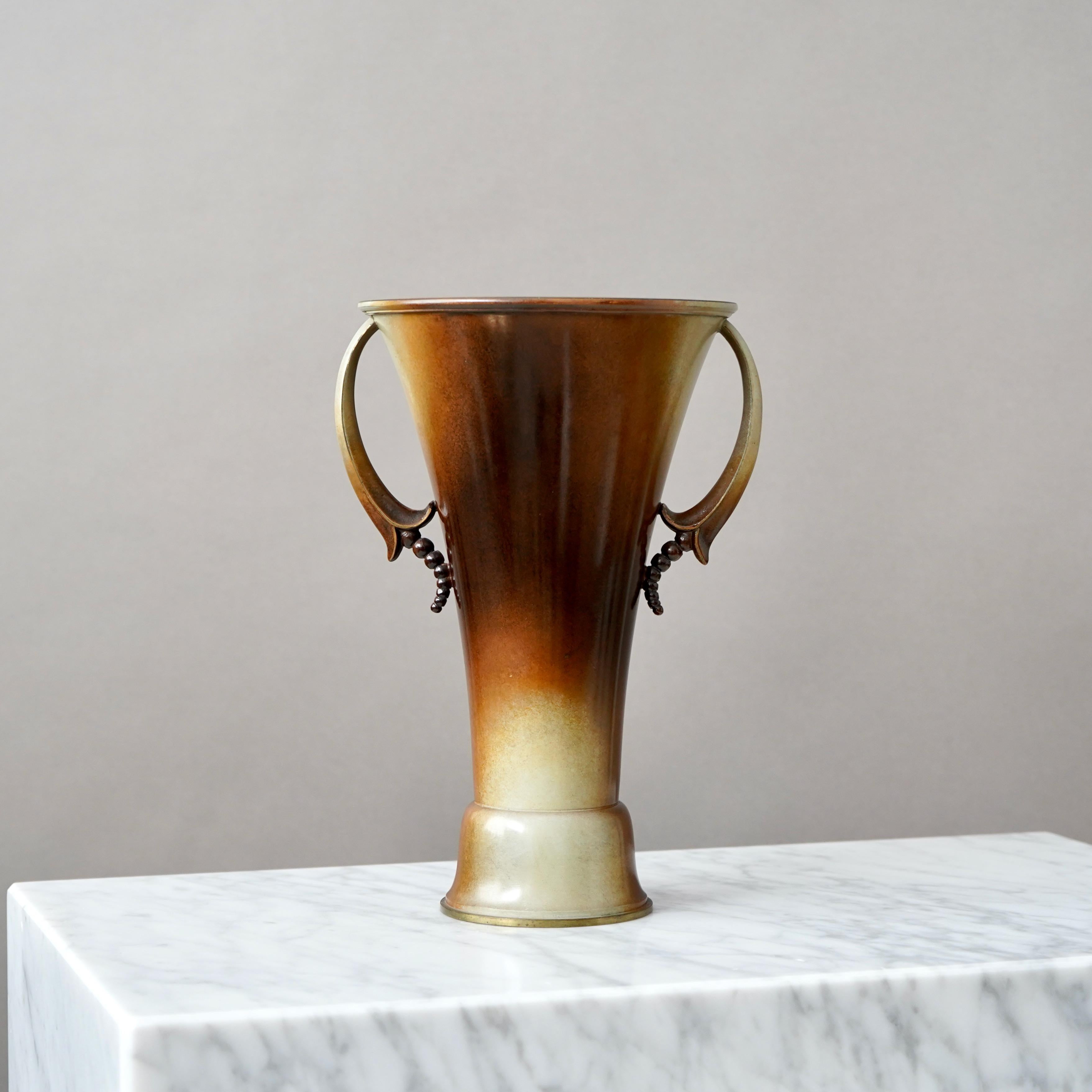 Elegante jarrón de bronce patinado. Art decó / Gracia sueca. 

Fabricado por Ystad Metall / Brons, Suecia, años 30.

Buen estado. Algo de desgaste en la pátina y ligeros arañazos.
Con el sello 