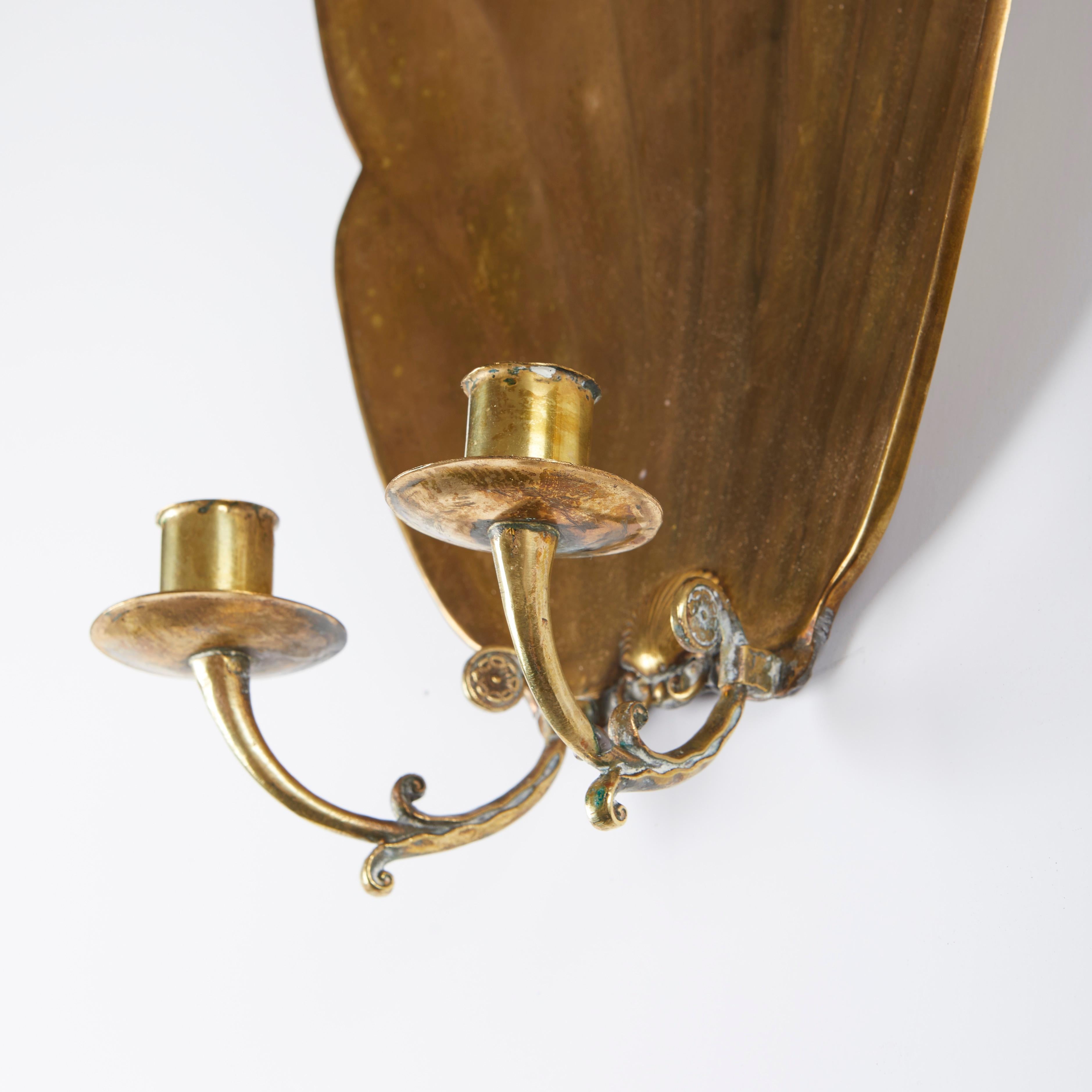 A pair of Swedish Grace shell-form sconces. The oversized backplates each issuing two arms, each electrified with one candelabra socket.