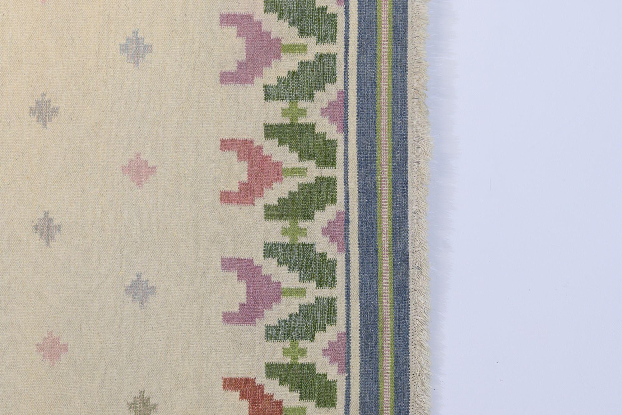 Ein wirklich schönes Beispiel für einen floral gemusterten schwedischen Kelim in Creme-, Blau- und Grüntönen mit einem Hauch von Rosa und Lila. Dieses Stück wurde während seiner gesamten Lebensdauer nicht ordnungsgemäß gelagert und zeigt Anzeichen