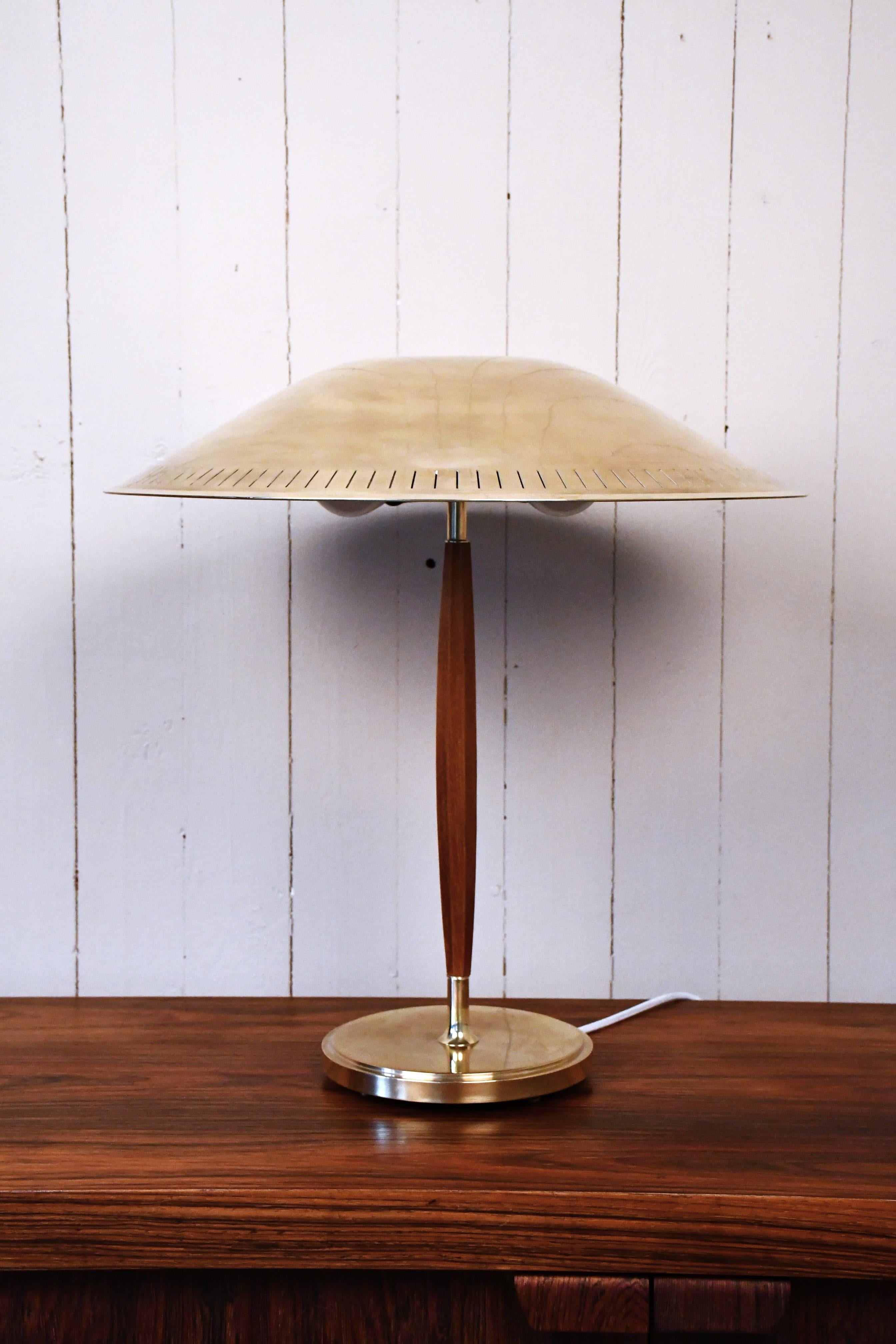 Grande lampe de table moderne suédoise en laiton et hêtre Modèle n° 15277 par Harald Notini pour Böhlmarks Lampfabrik AB, années 1940.
Très rare et grande lampe avec l'interrupteur sur le dessus de l'abat-jour. La lampe est en très bon état, elle