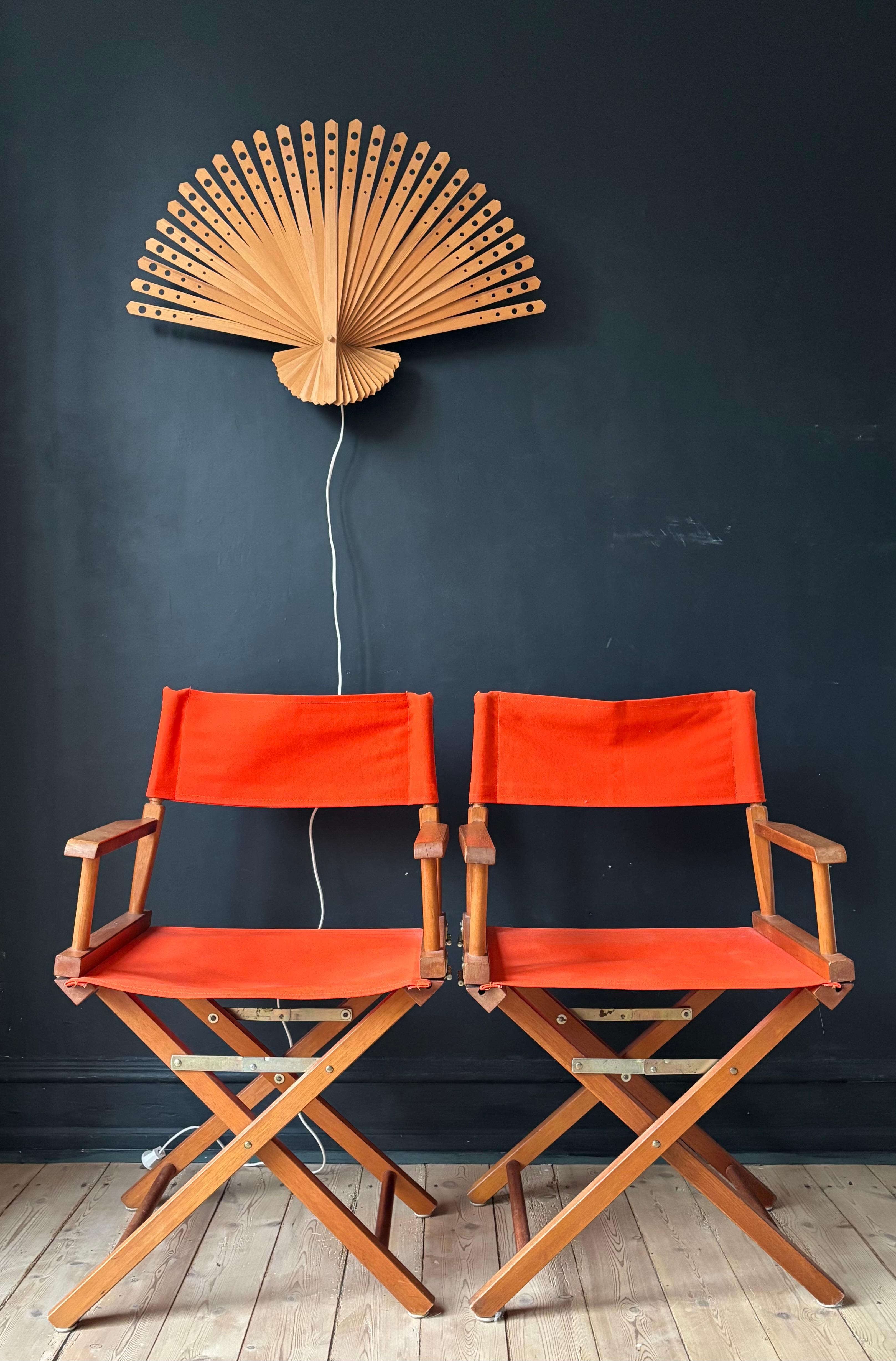 Very large handmade peacock fan shaped wall sconce composed of narrow pine wood slats with circular holes in four different sizes adding a symmetrical pattern when the bulb is lit. 
Wired for EU and US use with a Scandinavian plug. 
Beautiful