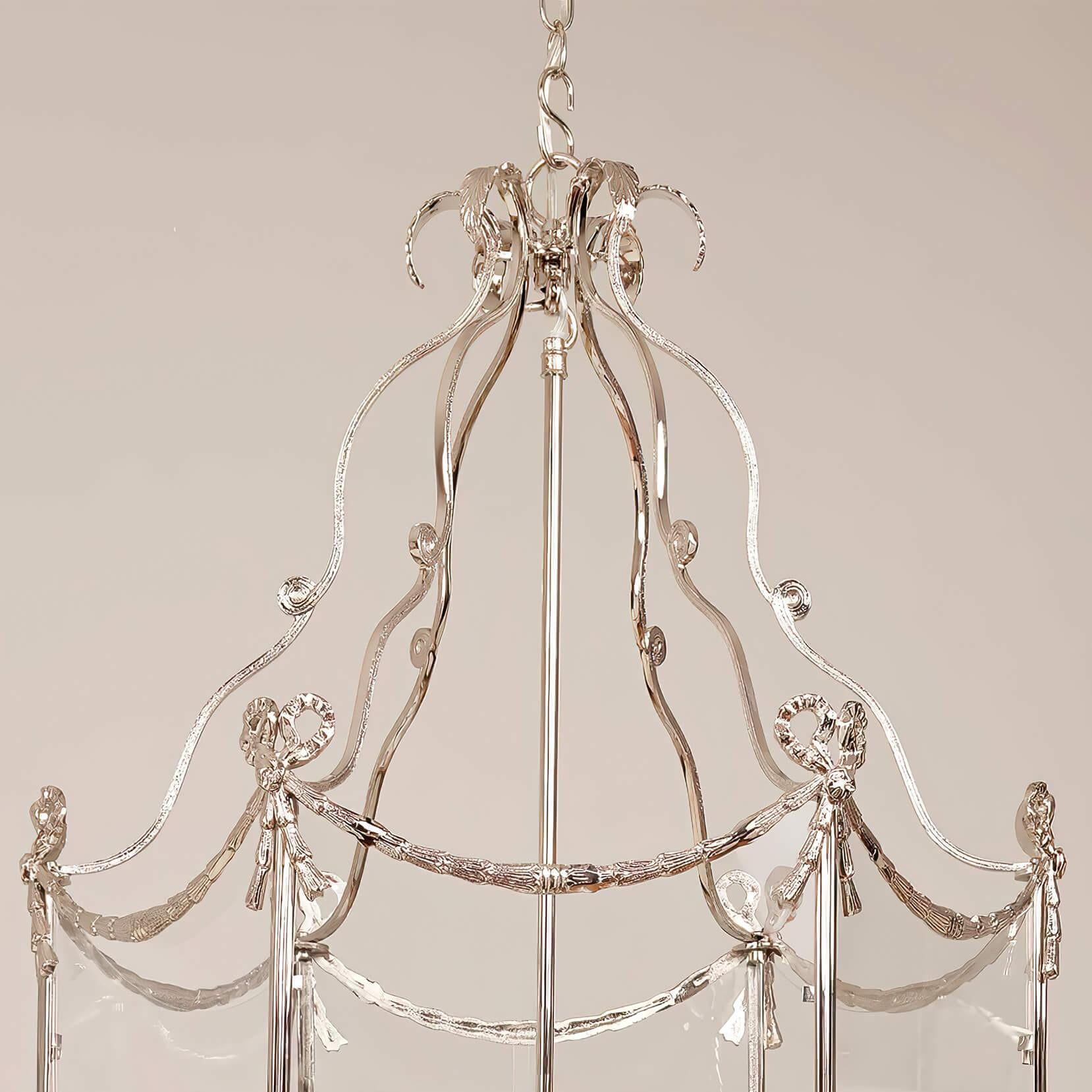 A large Swedish neoclassic style five-light brass hall lantern with 18th-century style embellishments. The leaf tip crown above scrolling supports and a hexagonal frame decorated with bowknots, tassels, and bellflower swags. The base is decorated